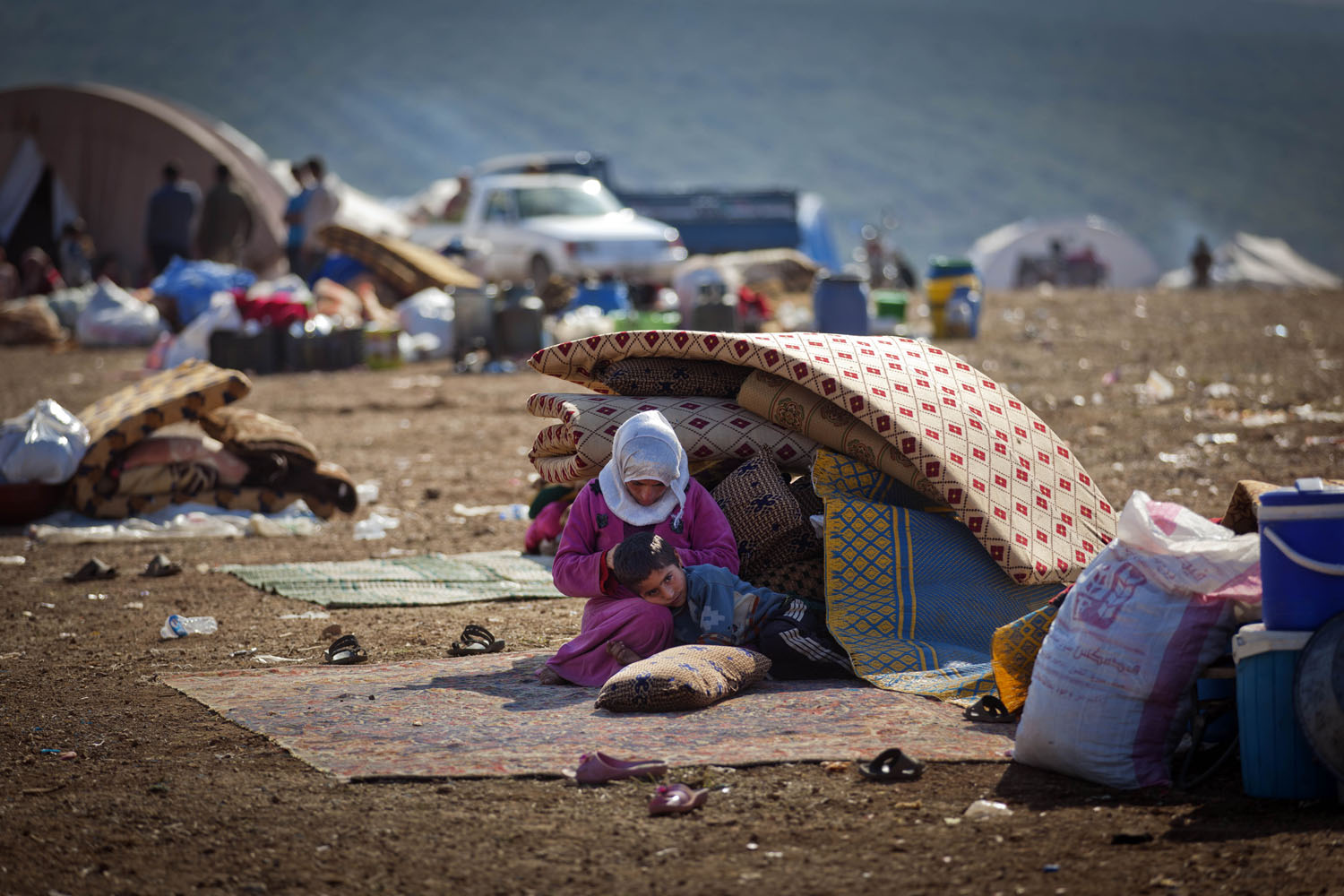 Image: Nov. 7, 2012. A Syrian family who fled from the violence in their village sit next to their belongings at a displacement camp in the Syrian village of Atma.