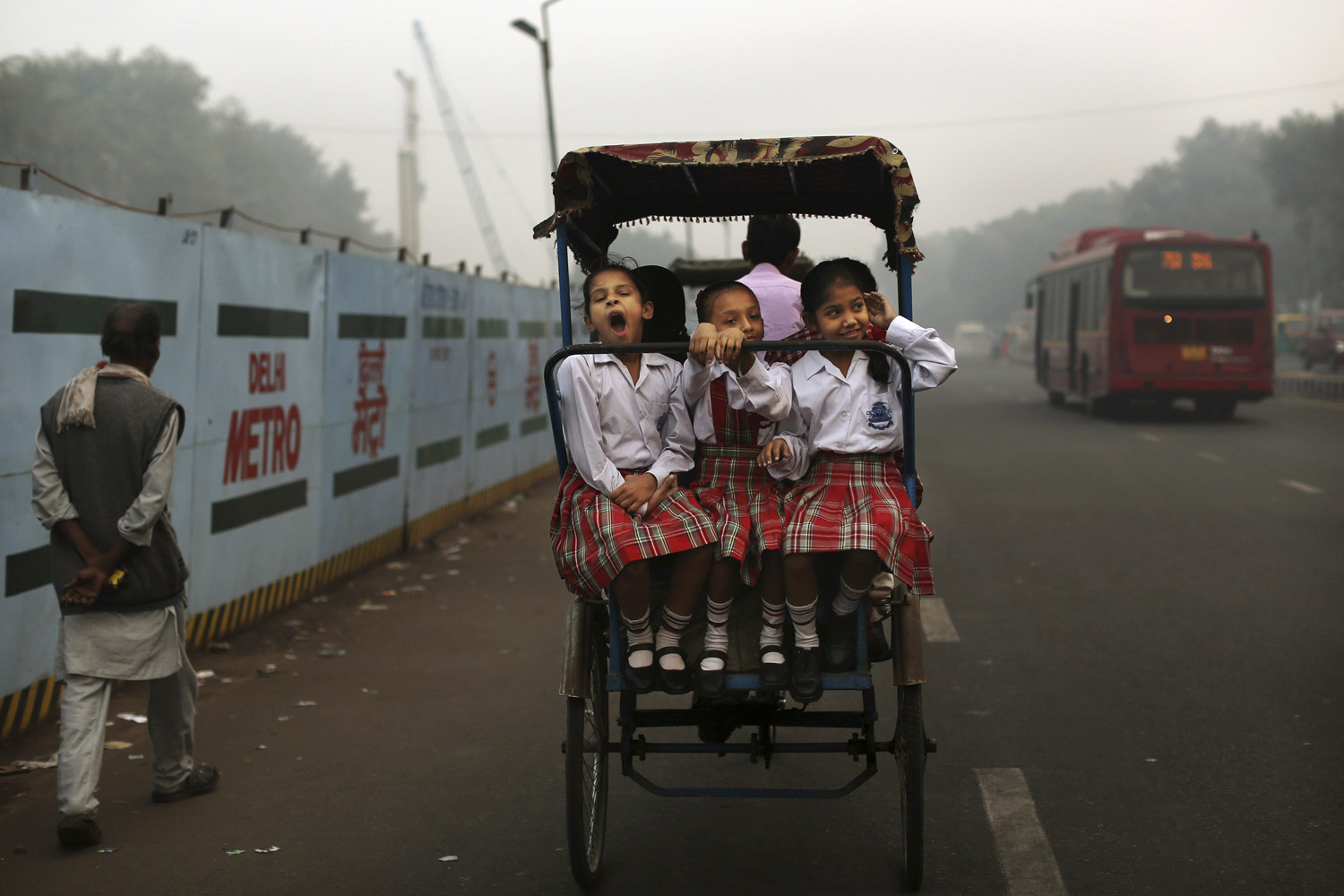 Image: Oct. 31, 2012. An Indian schoolgirl yawns as she rides with friends to school on a bicycle rickshaw in New Delhi.