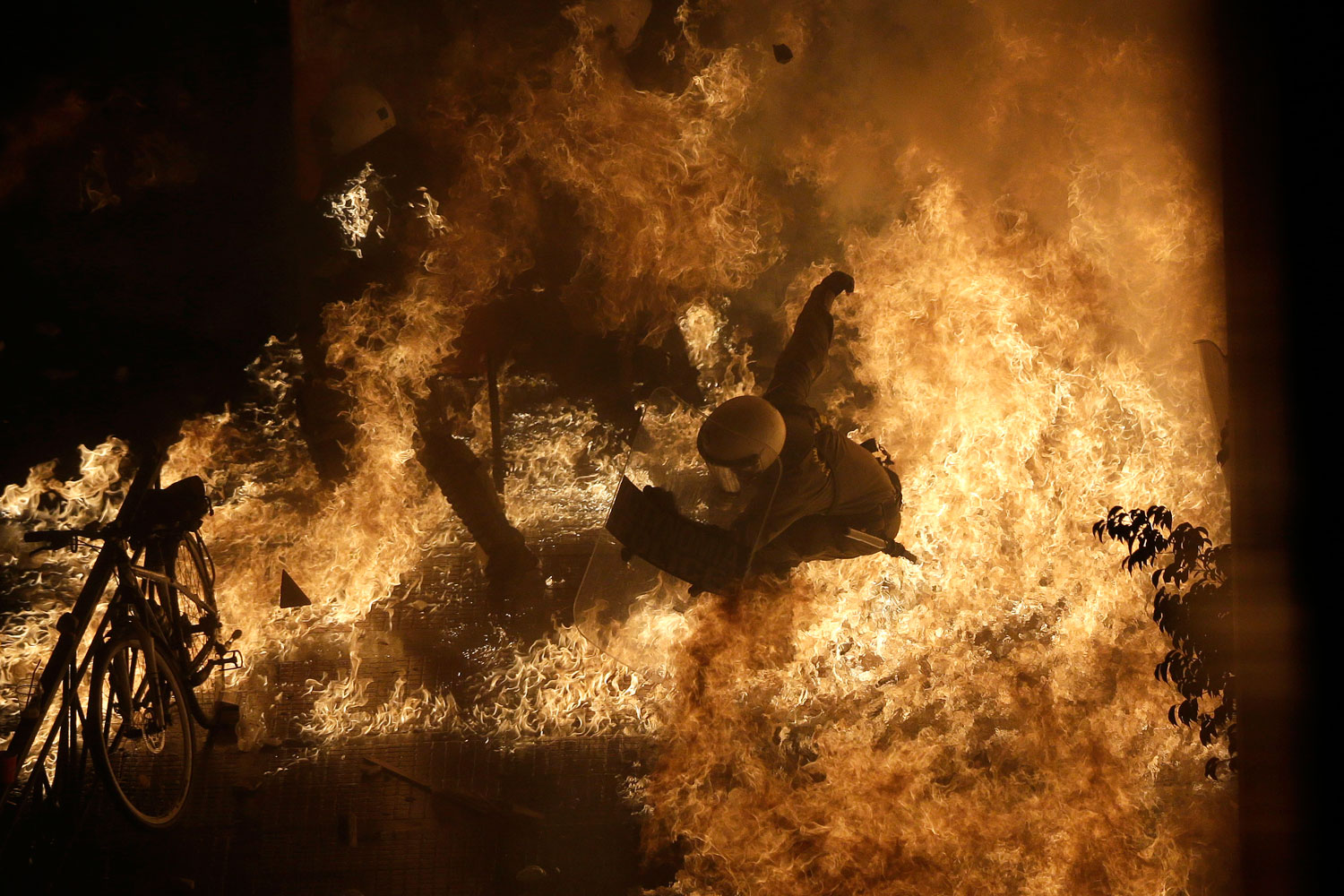 Image: Nov. 7, 2012. A riot police officer is engulfed by petrol bomb flames thrown by protesters in front of the parliament during clashes in Athens.