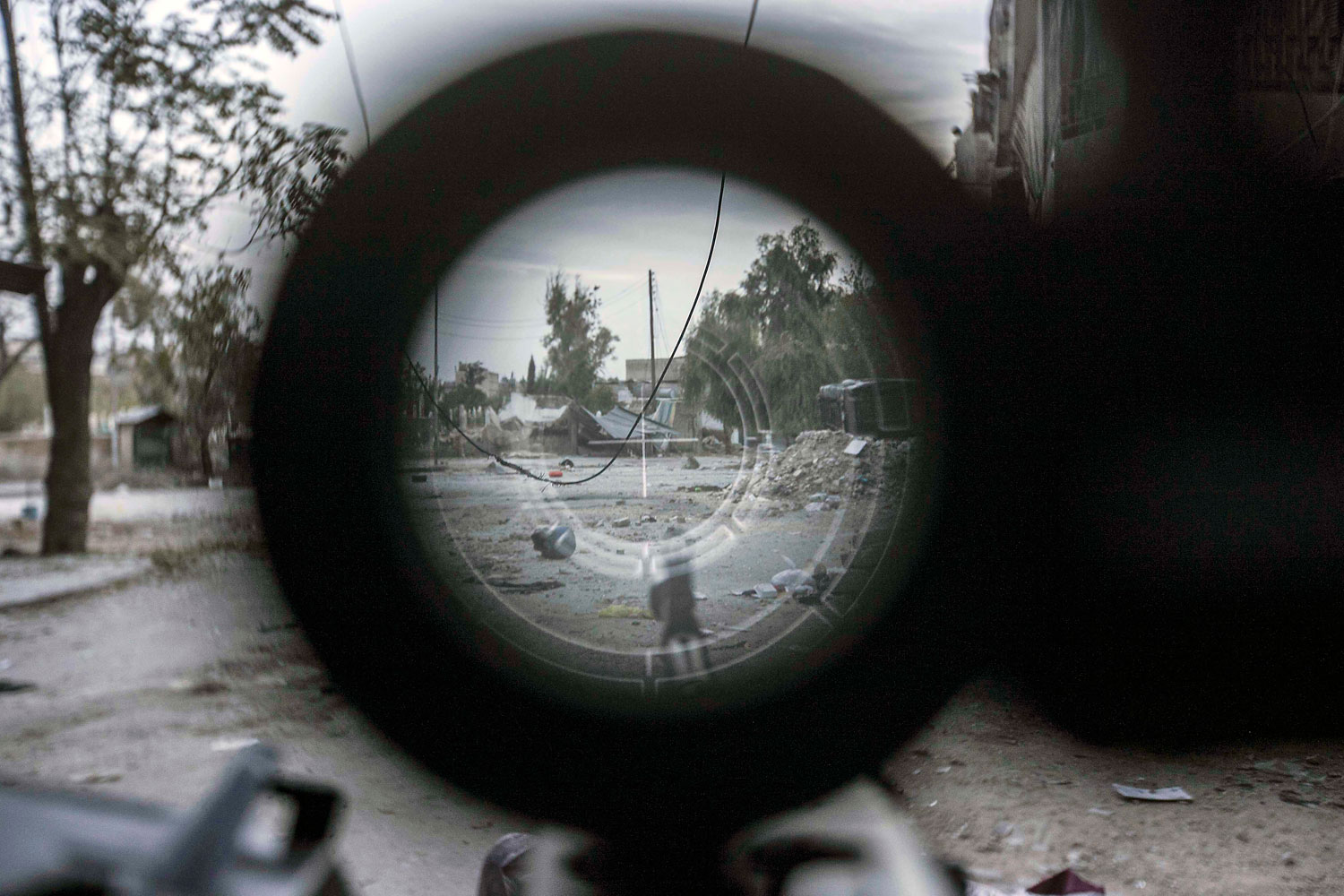 Image: Nov. 2, 2012. A sniper line-of-fire is seen through the scope of a rebel fighter's gun in the Karm al-Jebel neighborhood in Aleppo, Syria.