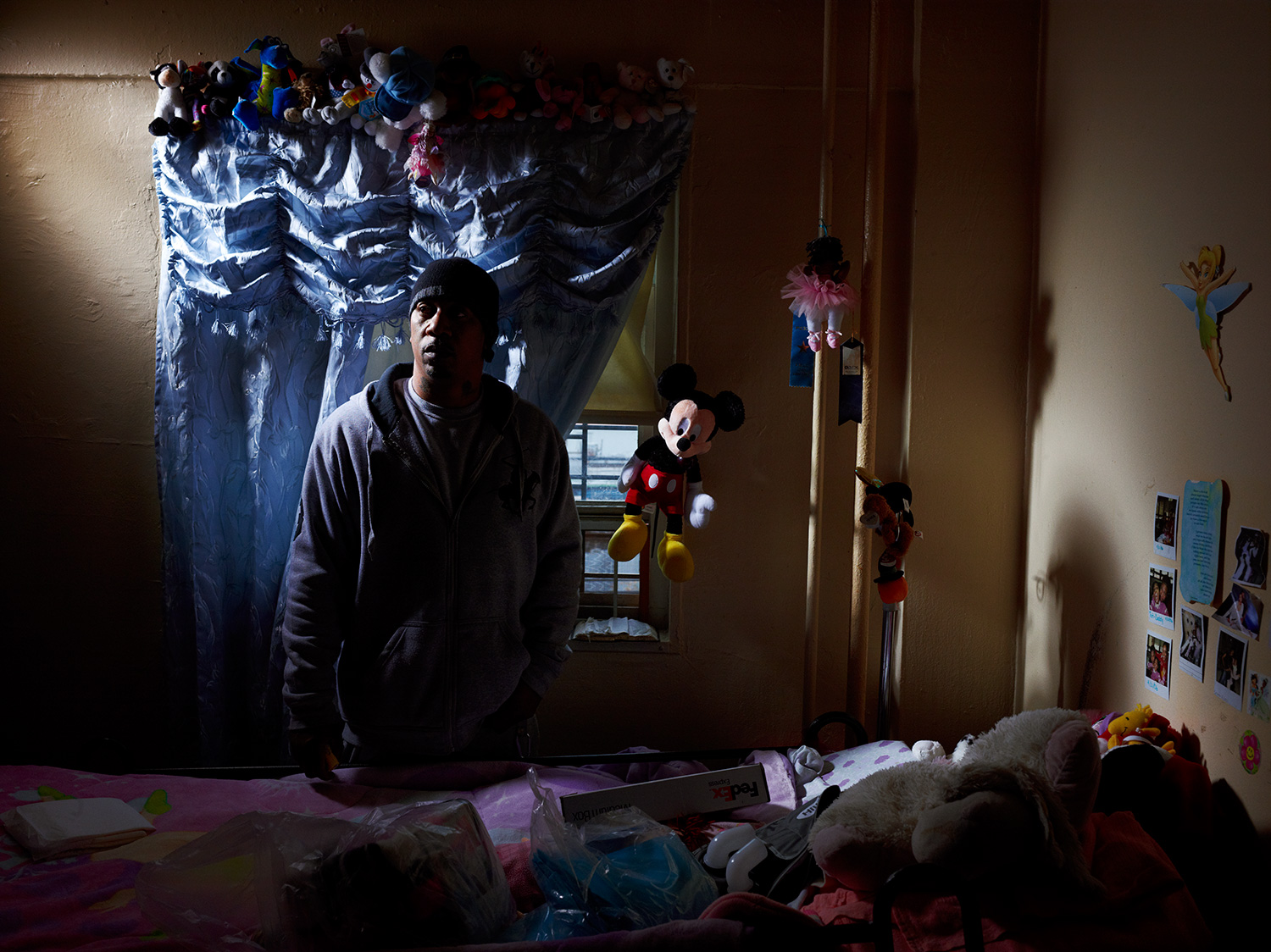 Image: David Stephens stands beside the hospital bed in his daughter Tatiana's room. The owner of a hair salon–named Three Angels Hair Salon after his daughters–until the economy forced him to shutter the business, David cares for his daughter in his sixth floor apartment in the Redfern Houses. Tatiana, now 17, suffered a brain infection at 9 that left her paralyzed. The morning after Sandy, David carried her down six flights of stairs after the power went out. Tatiana is staying with Stephens' mother-in-law. "This is the time to show who’s down for what," Stephens says of the Redfern community. "Everybody can walk past on a nice day and say, ‘I’m your neighbor.’ But when there’s tough time, where are you at? No we’re all standing on line. Now we’re all looking for help."