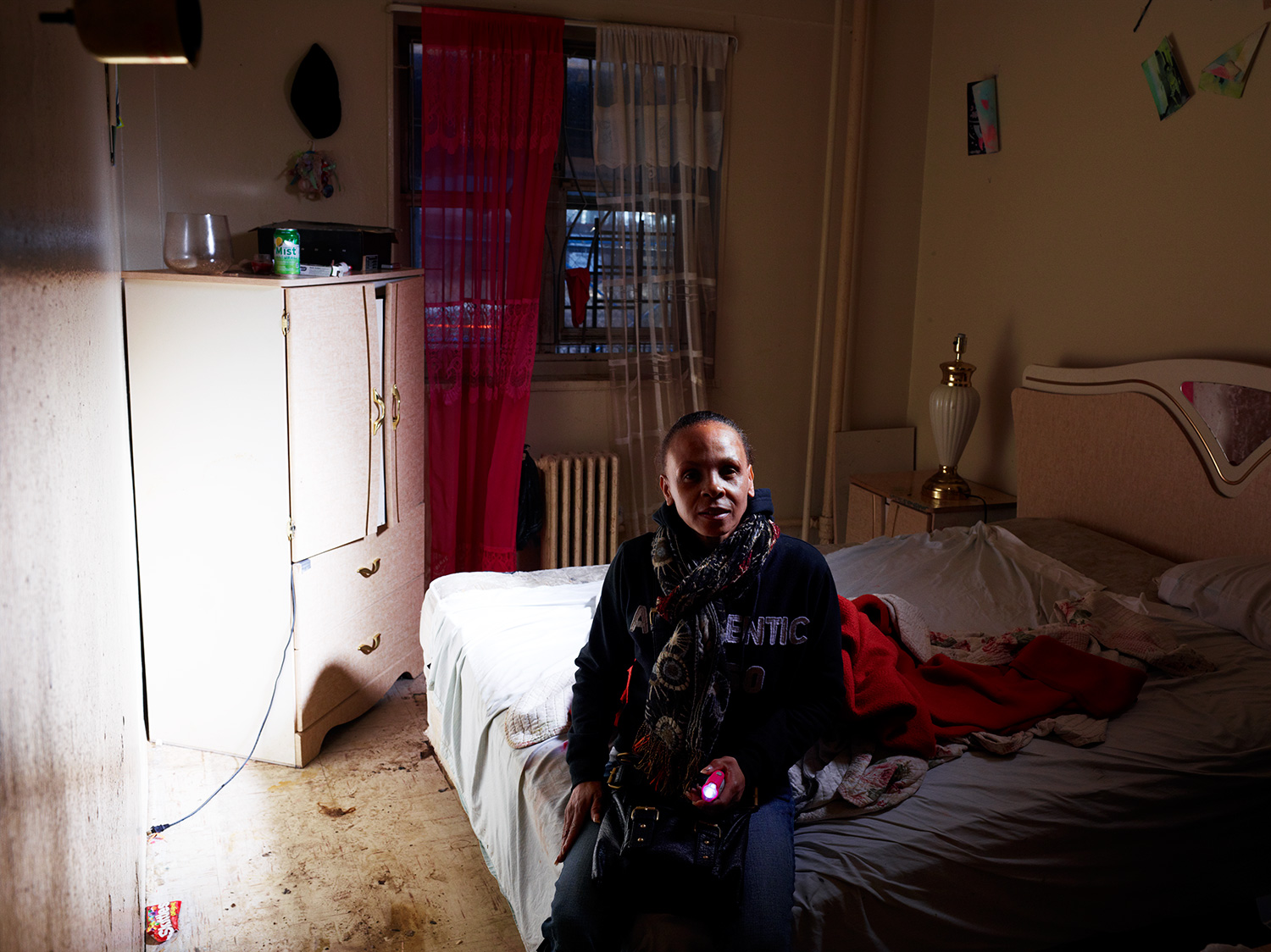 Image: Sheree Pinder sits on the water-soaked bed of one of her bedrooms on the first floor of the Redfern Houses.