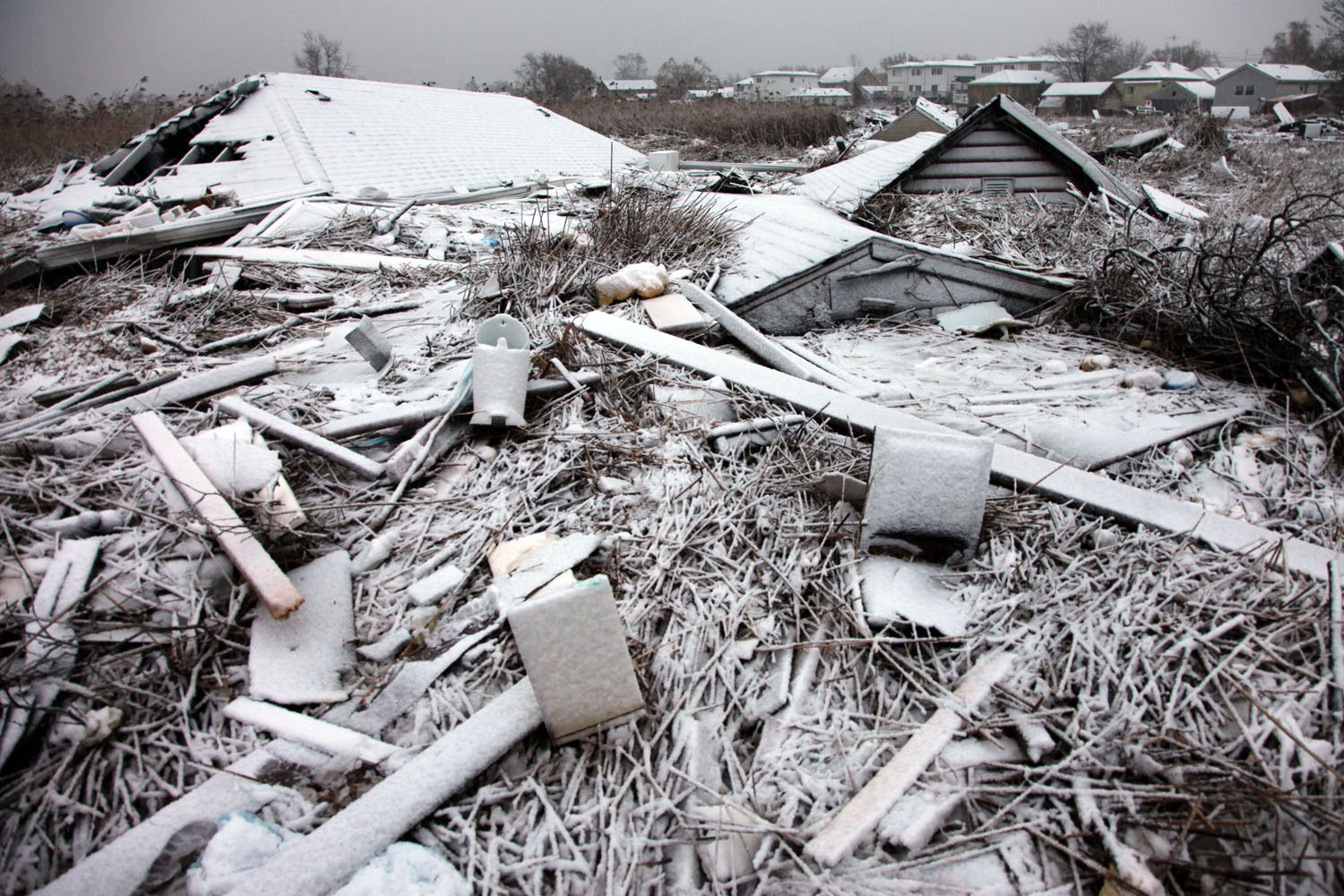Image: Nor’Easter snow settles on roofs and household debris carried by flood water and wind from Kissam Avenue to the marsh along Mill Road during Superstorm Sandy.