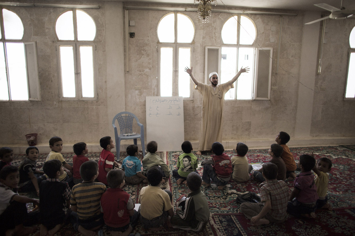 Sept. 17, 2012. Syrian teacher Abu al-Fattah gestures while delivering a lesson at an improvised school in the town of Azaz, Syria, on the border with Turkey.