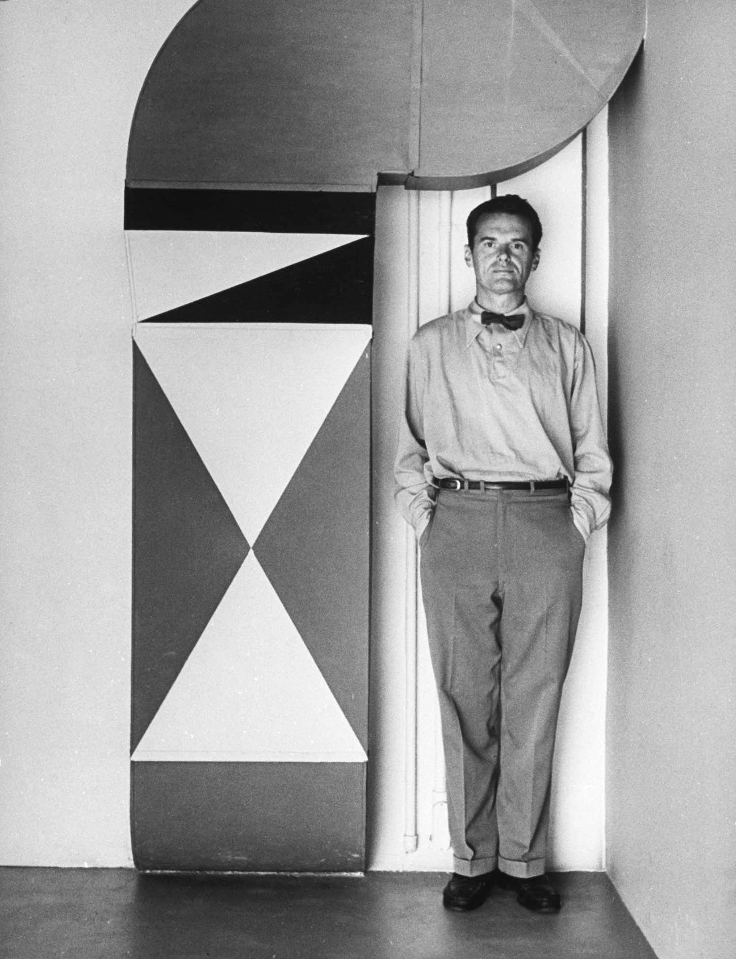 Charles Eames ... earnest, reticent, eternally bow-tied man of 43. Decoration on heating duct at left is a piece of Eames whimsy.