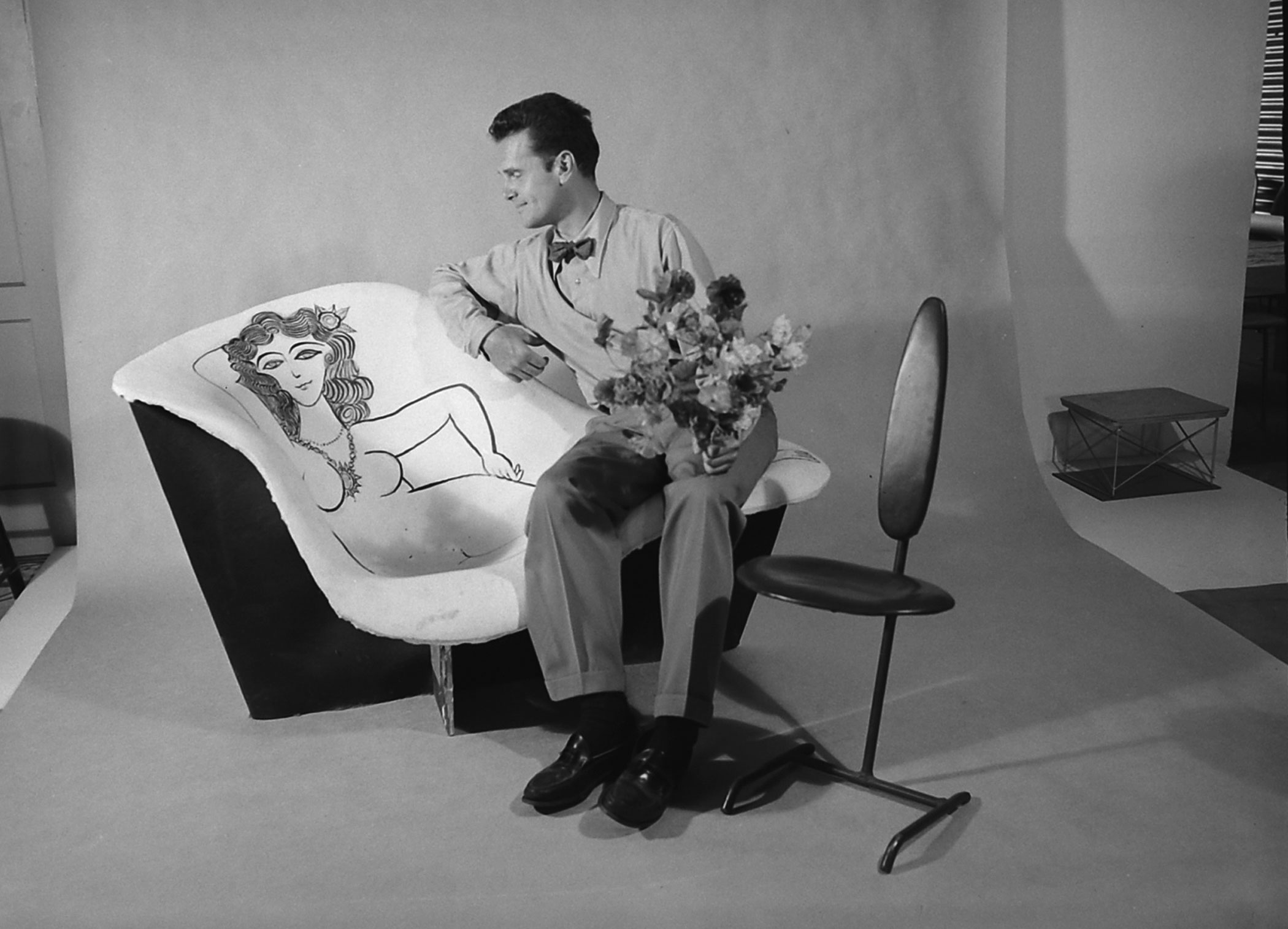 Charles Eames with a chair he designed and decorated, California, 1950.