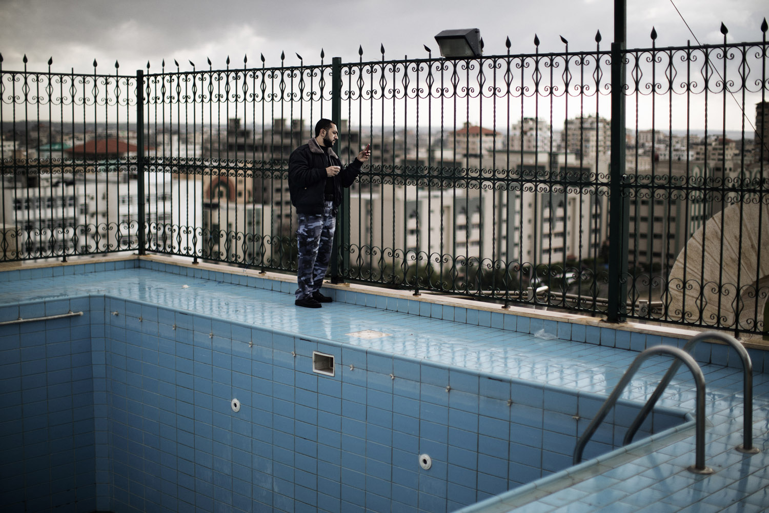 Dec. 8, 2012. A Palestinian Hamas policeman takes pictures with his phone from the rooftop of a building overlooking a rally in Gaza City. More than 100,000 Palestinians gathered for the rally, which marked the 25th anniversary of Hamas.