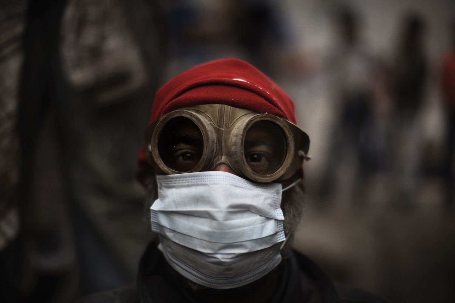 Feb. 6, 2012. An Egyptian demonstrator uses goggles and a mask to shield himself from tear gas fired by riot police during confrontations outside Cairo's security headquarters. Clashes continued in the wake of deadly football violence in Port Said amid calls by activists for civil disobedience.