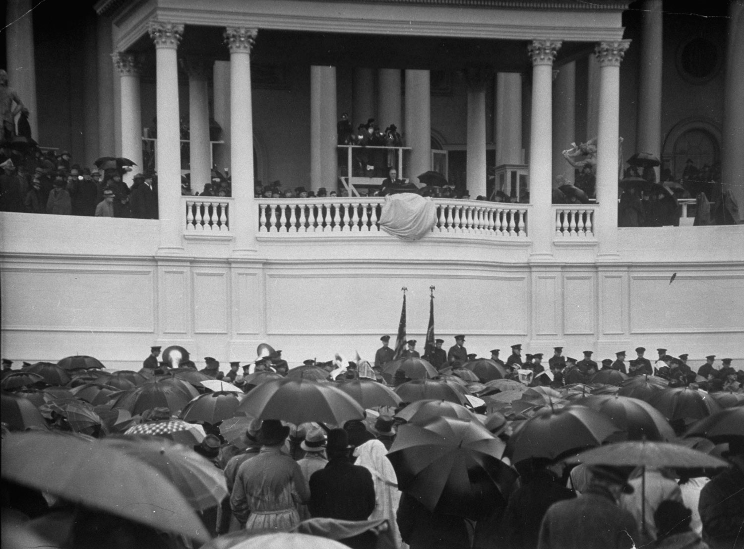 A crowd of 40,000 stands in the rain in front of the main entrance to the Capitol Building to witness Franklin D. Roosevelt's first inauguration, 1933.