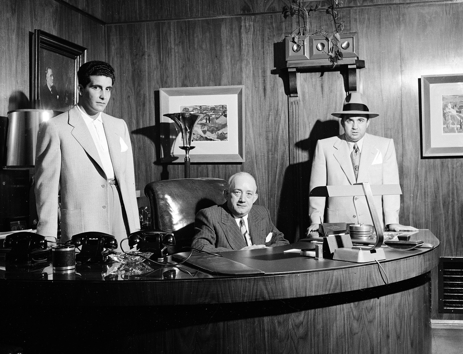Mickey Cohen's enforcer, "Johnny Stomp" Stompanato (famously stabbed and killed by Lana Turner's 14-year-old daughter, Cheryl Crane, in 1958), business manager Mike Howard and Cohen pose in Cohen's office in Los Angeles, 1949.