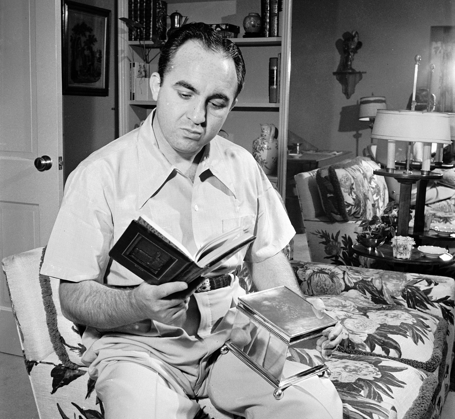 Gangster Mickey Cohen at home with a book given to him by the Hebrew Committee of National Liberation, Los Angeles, 1949.