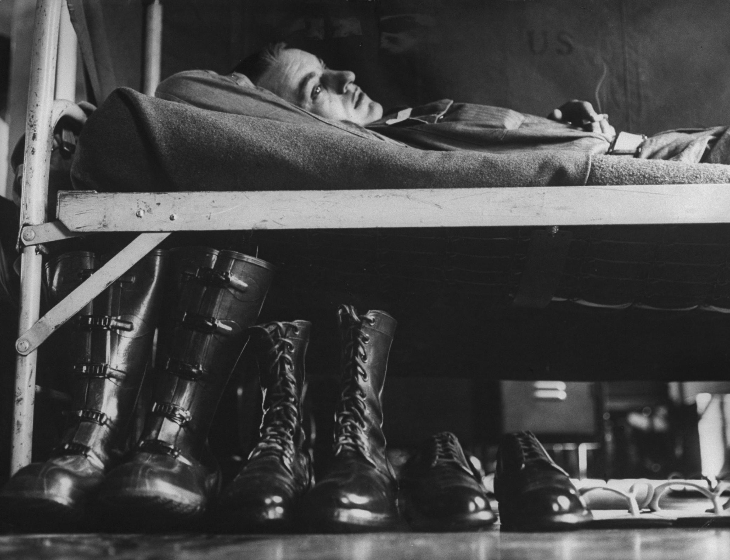 A draftee relaxes on his bunk during basic training, Fort Carson, Colorado, 1955.