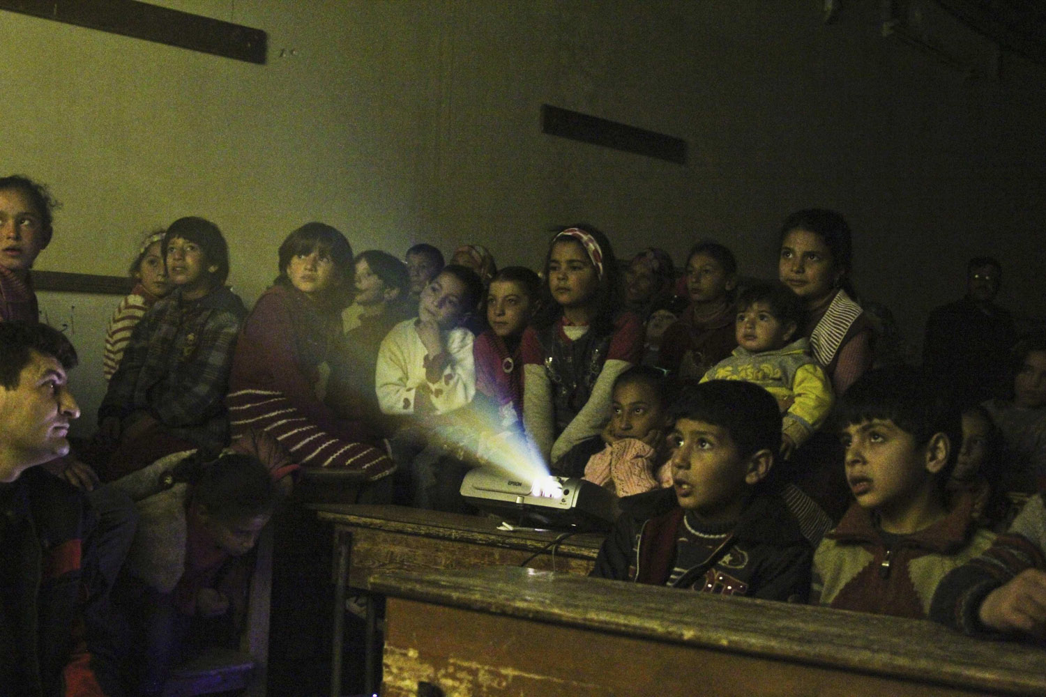 Jan. 16, 2013. Internally displaced children watch cartoons in a classroom of a school in Kafranbel in Idlib province, Syria. (Giath Taha—Reuters)