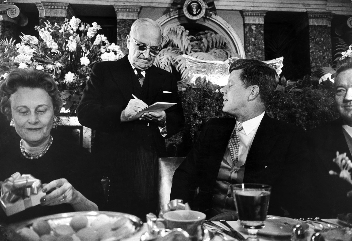 President John Kennedy watches former President Harry Truman sign an autograph for him at the inaugural luncheon, 1961.