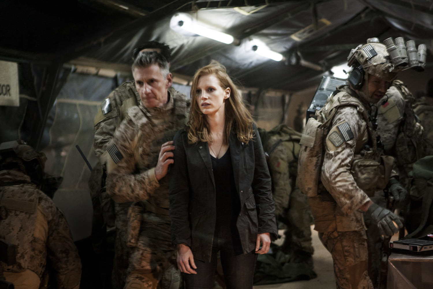 Stationed in a covert base overseas, Jessica Chastain (center) plays a member of the elite team of spies and military operatives (Christopher Stanley, LEFT and Alex Corbet Burcher, RIGHT) who secretly devoted themselves to finding Osama Bin Laden in Zero Dark Thirty.