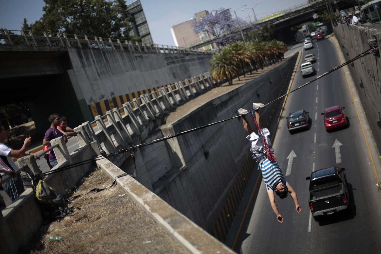 Feb. 24, 2013. Luis Amezquita hangs upside down over the Periferico avenue during a slacklining practice in Guatemala City, Guatemala.