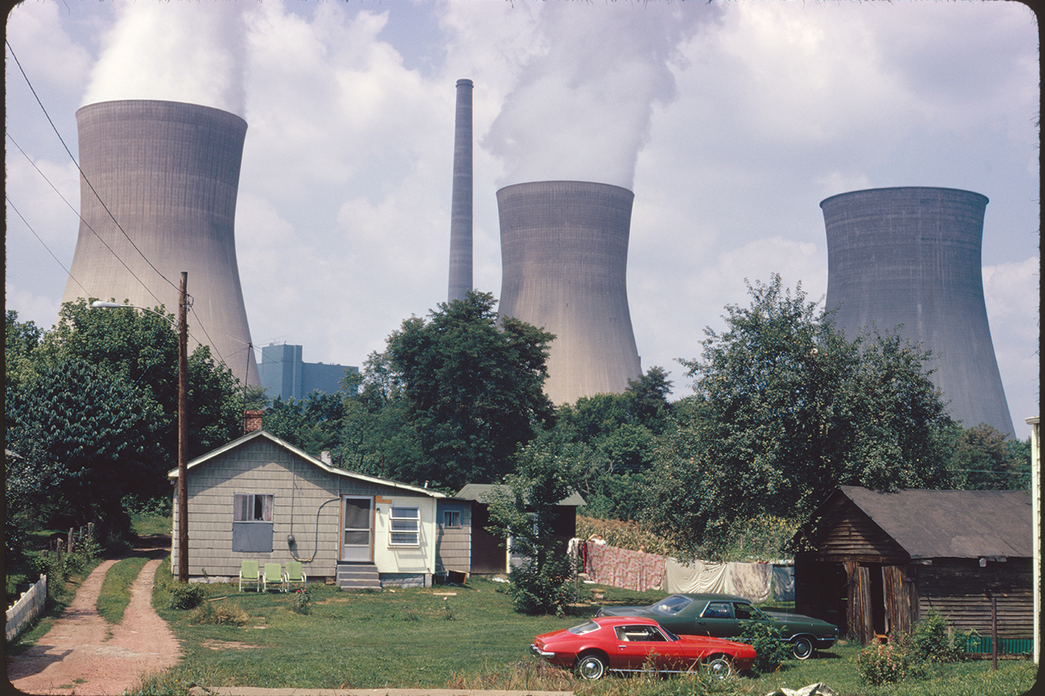 Water cooling towers of the John Amos Power Plant loom over Poca, WV, 1973.