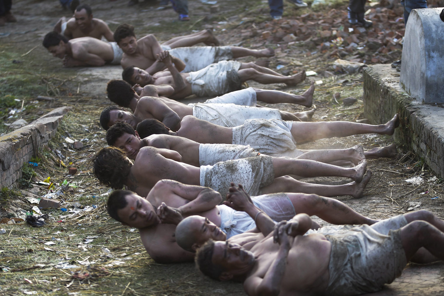 Feb. 25, 2013. Nepalese Hindu devotees roll on the ground before taking a holy bath in the Hanumante river during the last day of the month long Madhav Narayan festival, in Bhaktapur, Nepal.