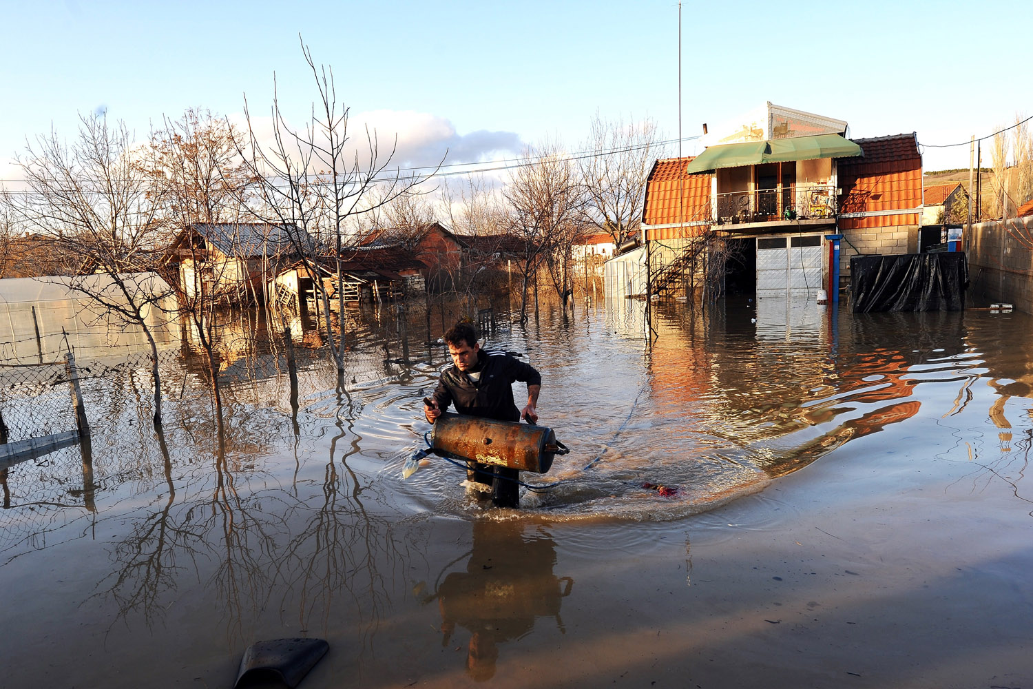 Feb. 26, 2013. A man carries his belongings from his flooded home in the town of Sveti Nikole, some 60 kilometers northeast from Skopje, Macedonia.