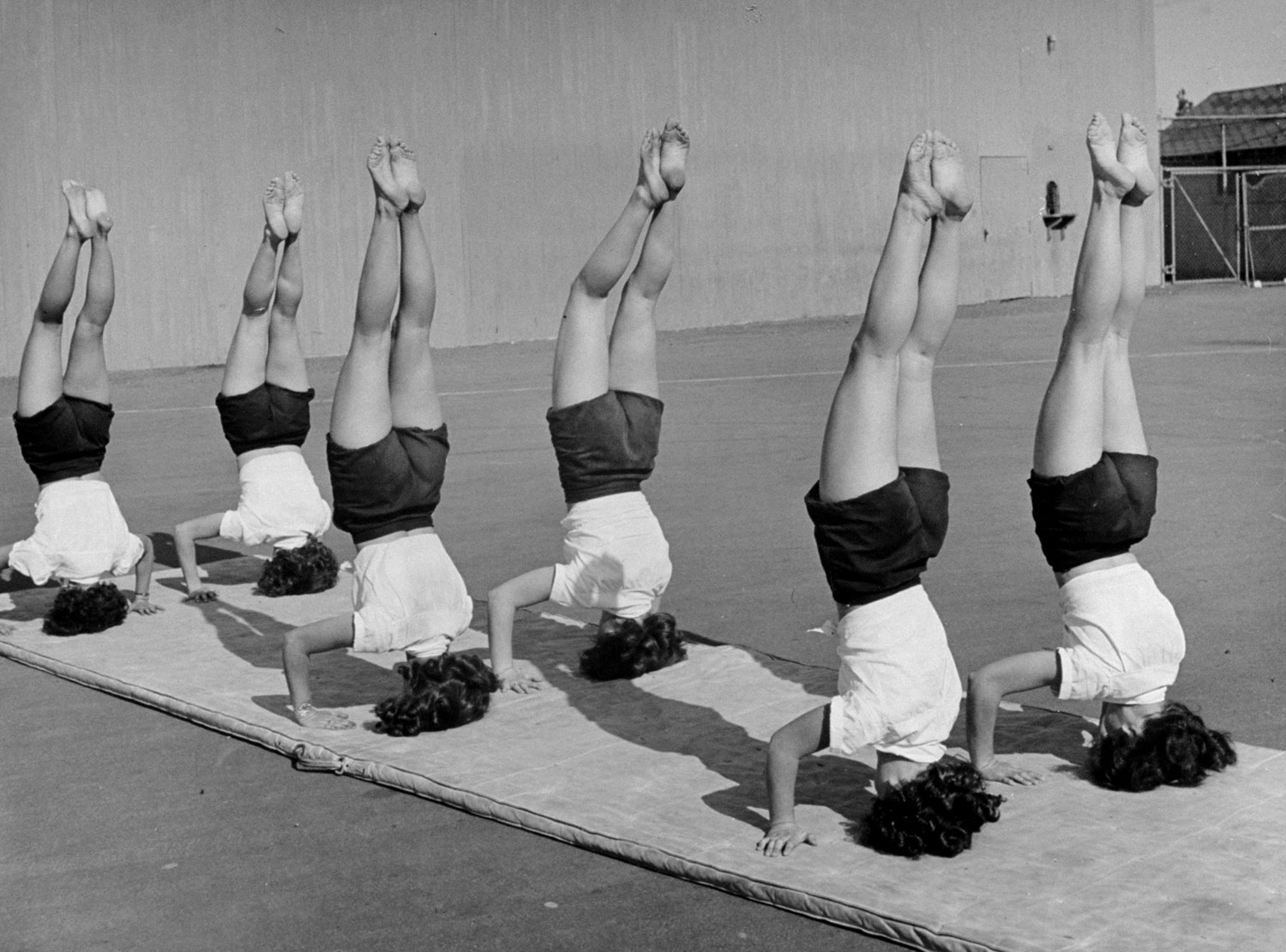 Girls from Hoover High School stand on their heads in gymnastics class, San Diego, Calif., 1946.