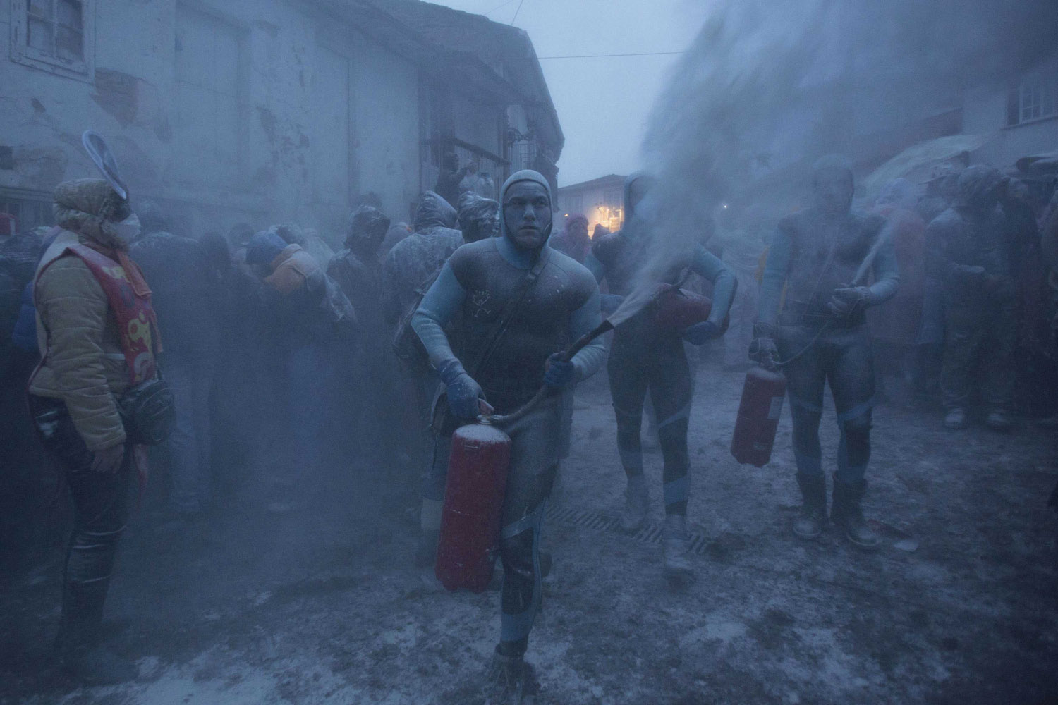 Revellers use fire extinguishers during a flour fight at the "O Entroido" festival in Spain's northwestern village of Laza