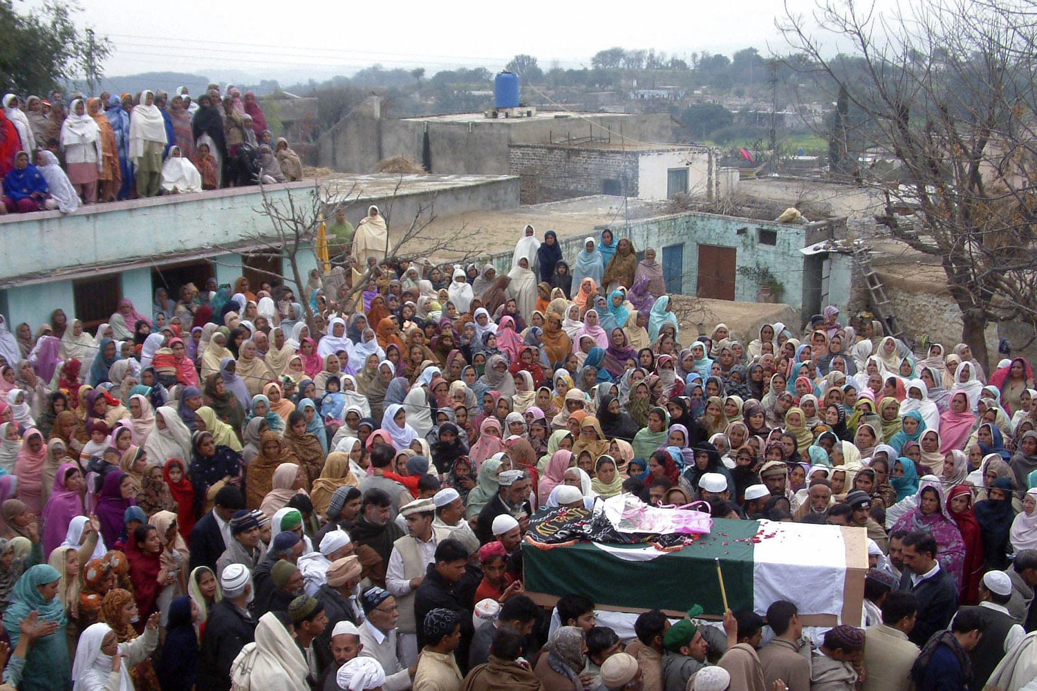 Villagers gather around the flag-draped casket of Pakistani soldier Muhammad Akhlaq, whom the Pakistan military said was killed by Indian soldiers after crossing into the Indian side of Kashmir, before funeral prayers at his village Pind Bainso