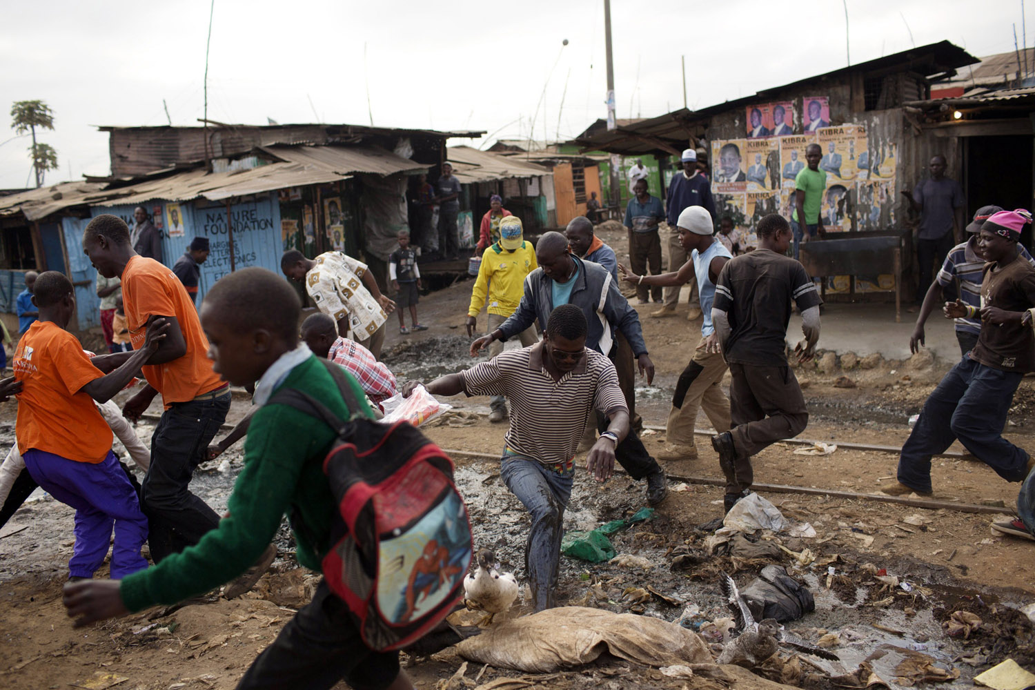 Feb. 27, 2013. Men scramble to get hold of t-shirts of the Orange Democratic Movement (ODM) during a campaign in Kibera slum in Nairobi, Kenya.