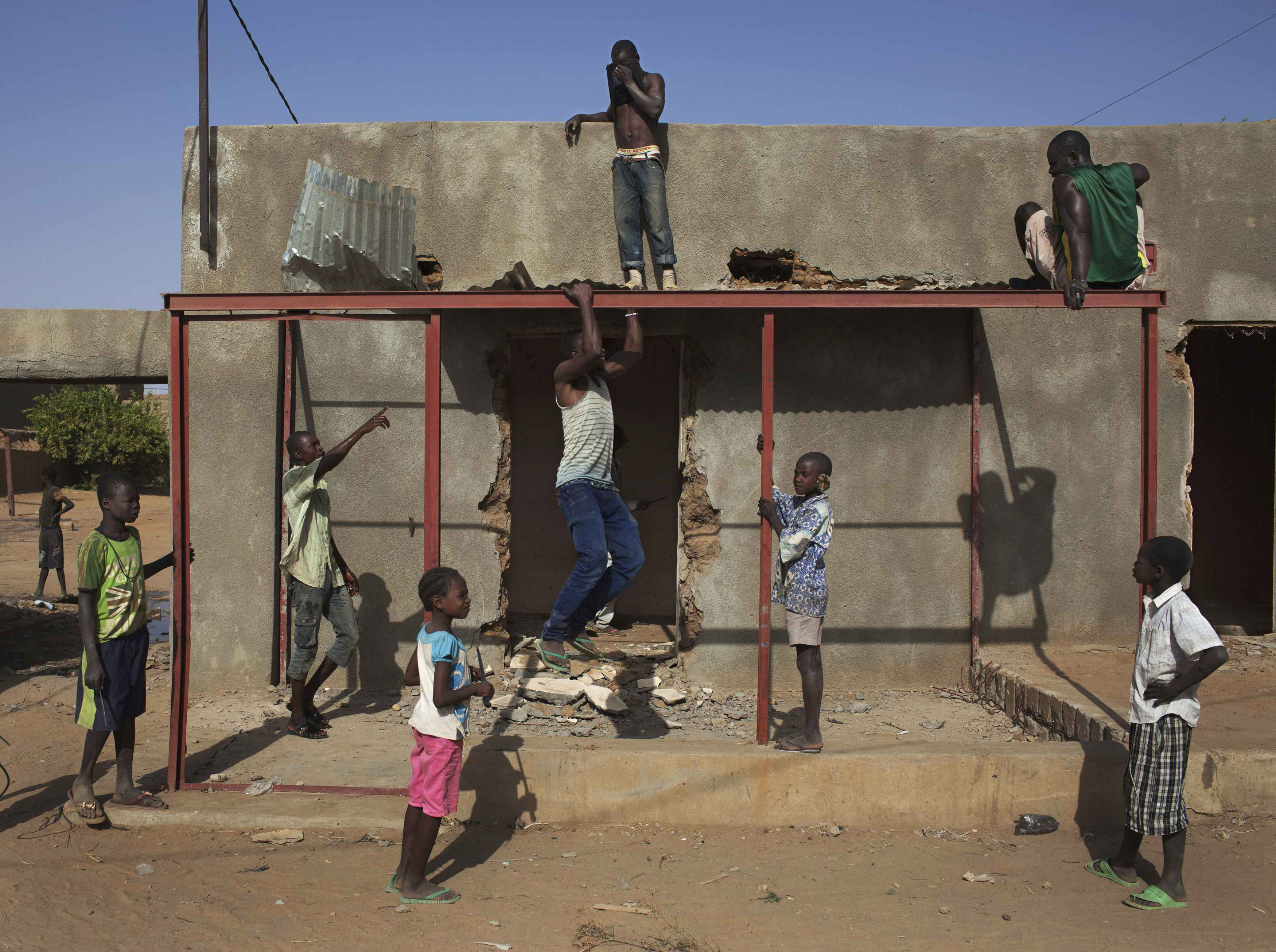 Feb. 28, 2013. Local residents take apart a house that was used by radical Islamists to store explosives, in Gao, Mail.