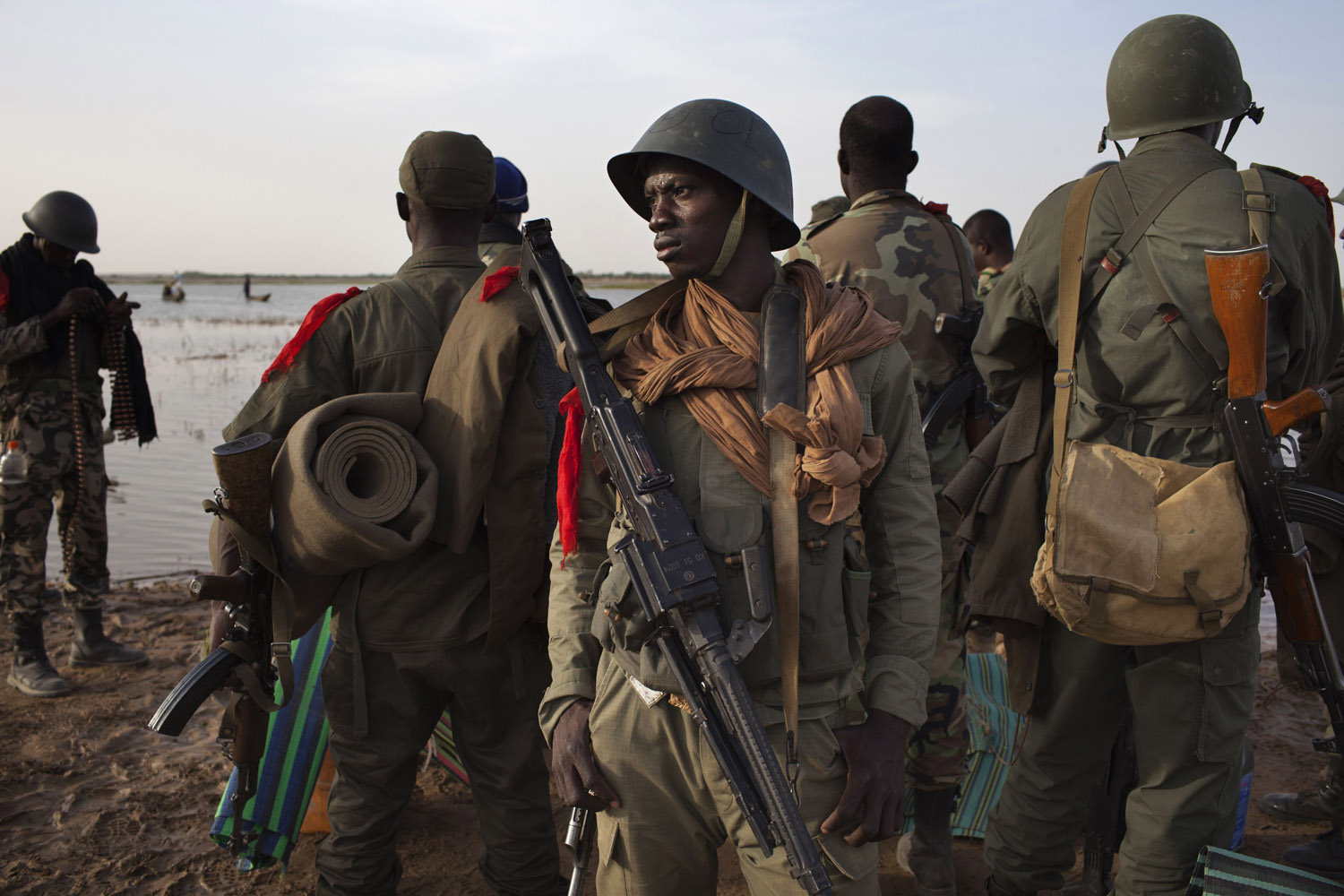 Malian soldiers gather on the banks of the Niger River before taking a canoe to the village of Kadji in Gao