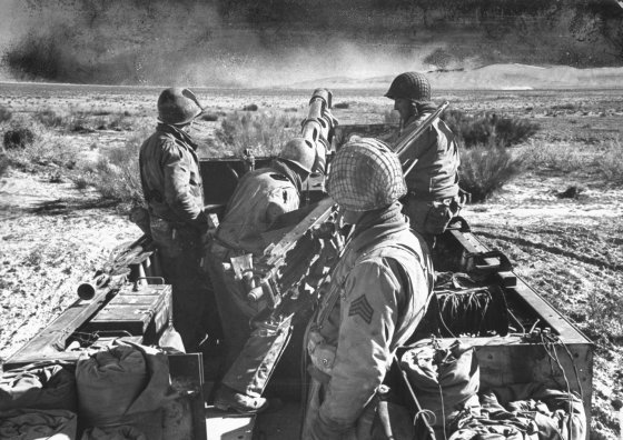 A tank-artillery team stands on alert. This kind of unit -- a 105mm. howitzer mounted on a half-track -- has proved a 'winning combination,' according to Army experts, in ground warfare in Tunisia.