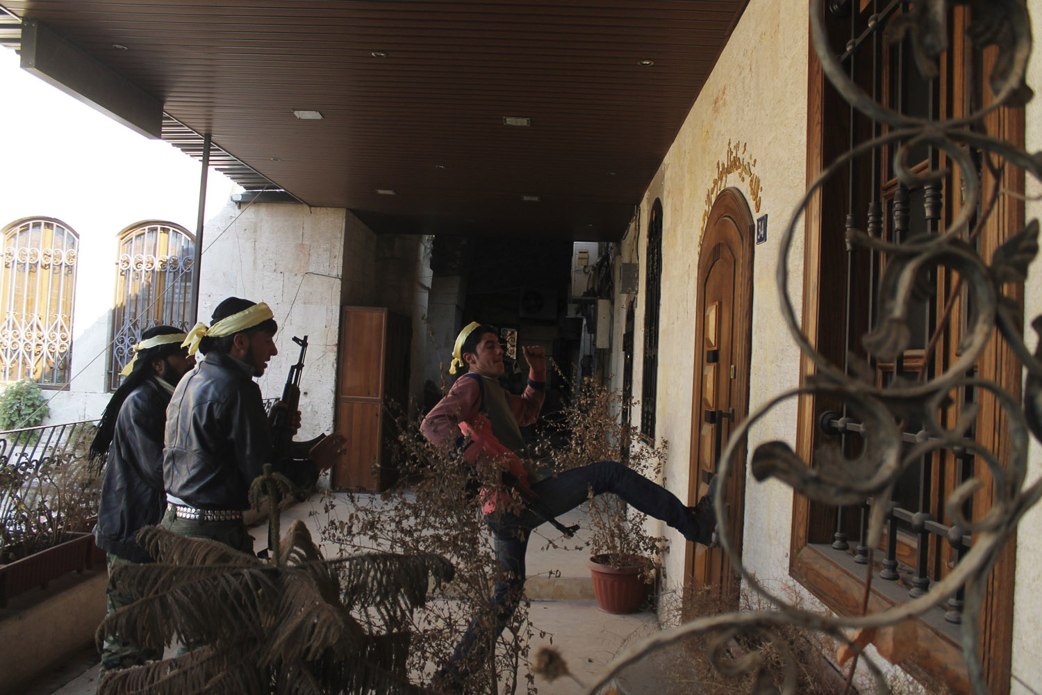 Members of the Free Syrian Army break into a house in the old city of Aleppo