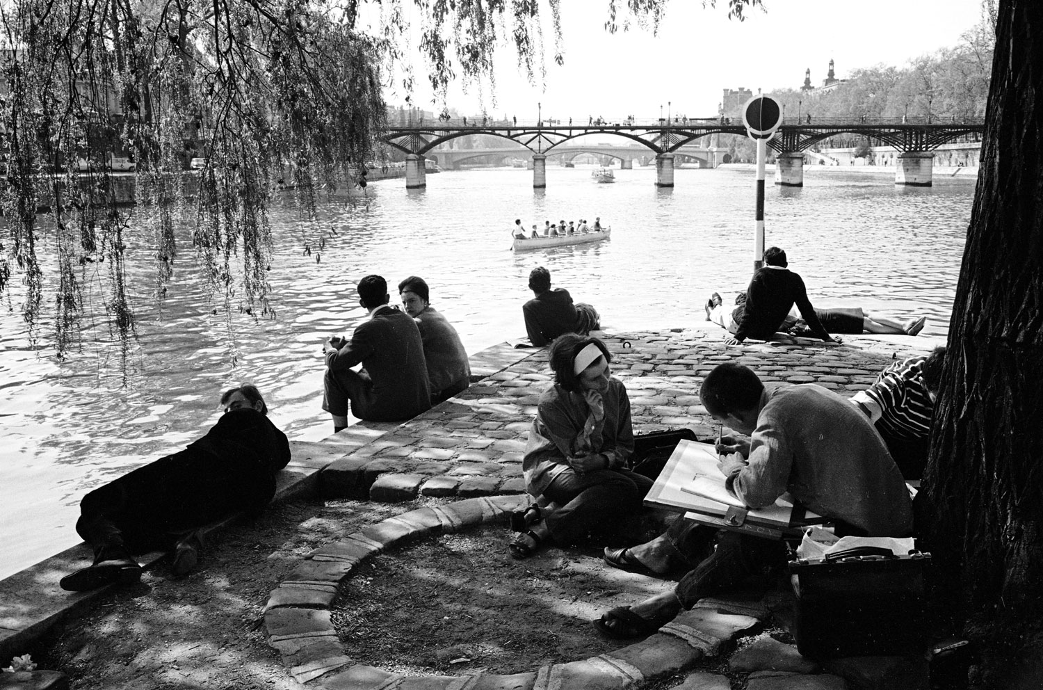 People enjoying an afternoon on the banks of the Seine River, 1963.