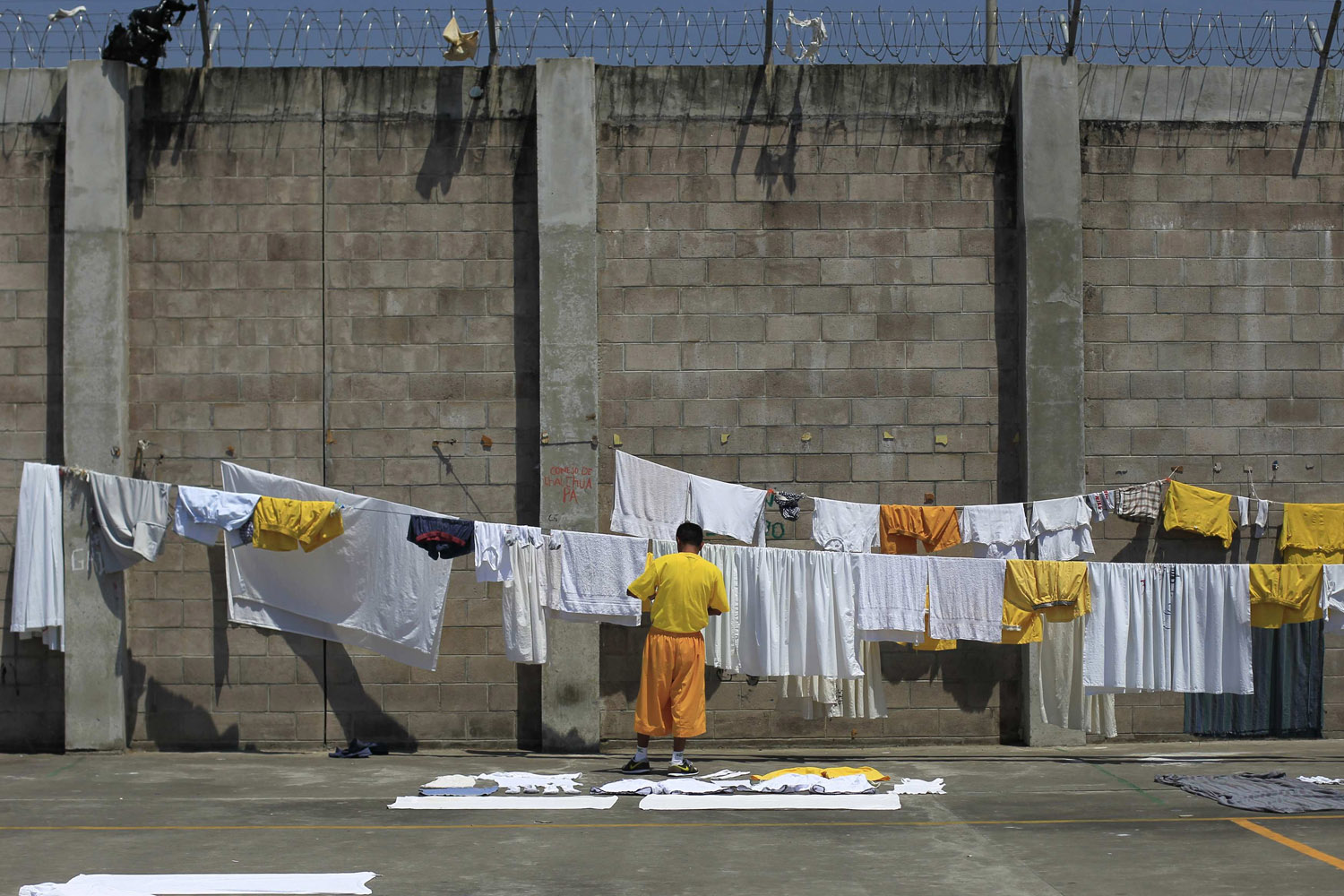 A jailed gang member hangs up laundry at the maximum security jail of Izalco in Sonsonate