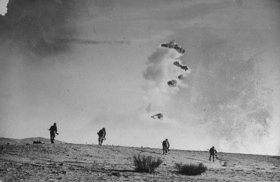 American soldiers charge into wall of smoke during a raid on German positions at Sened in the North African campaign, Tunisia, 1943.