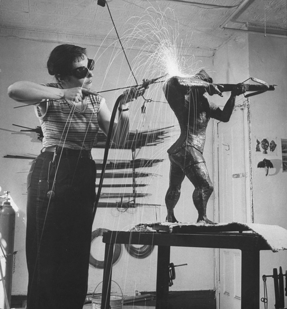 Sculptress Ruth Vodicka alters the shoulder of her statue of William Tell, 1956. (She also used her tools to do welding repairs for neighbors.)