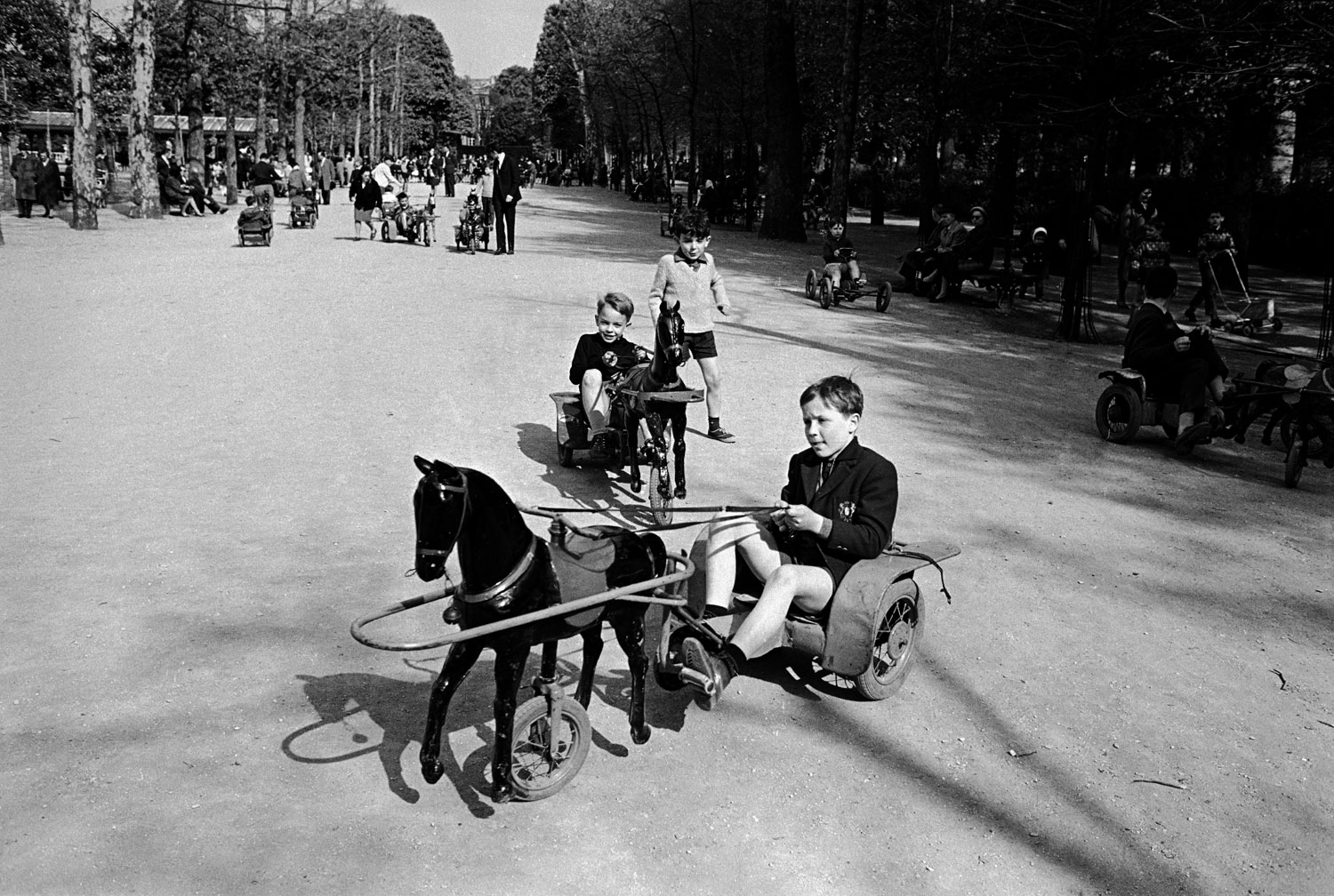 French children playing on toy horse and buggy vehicles, 1963.