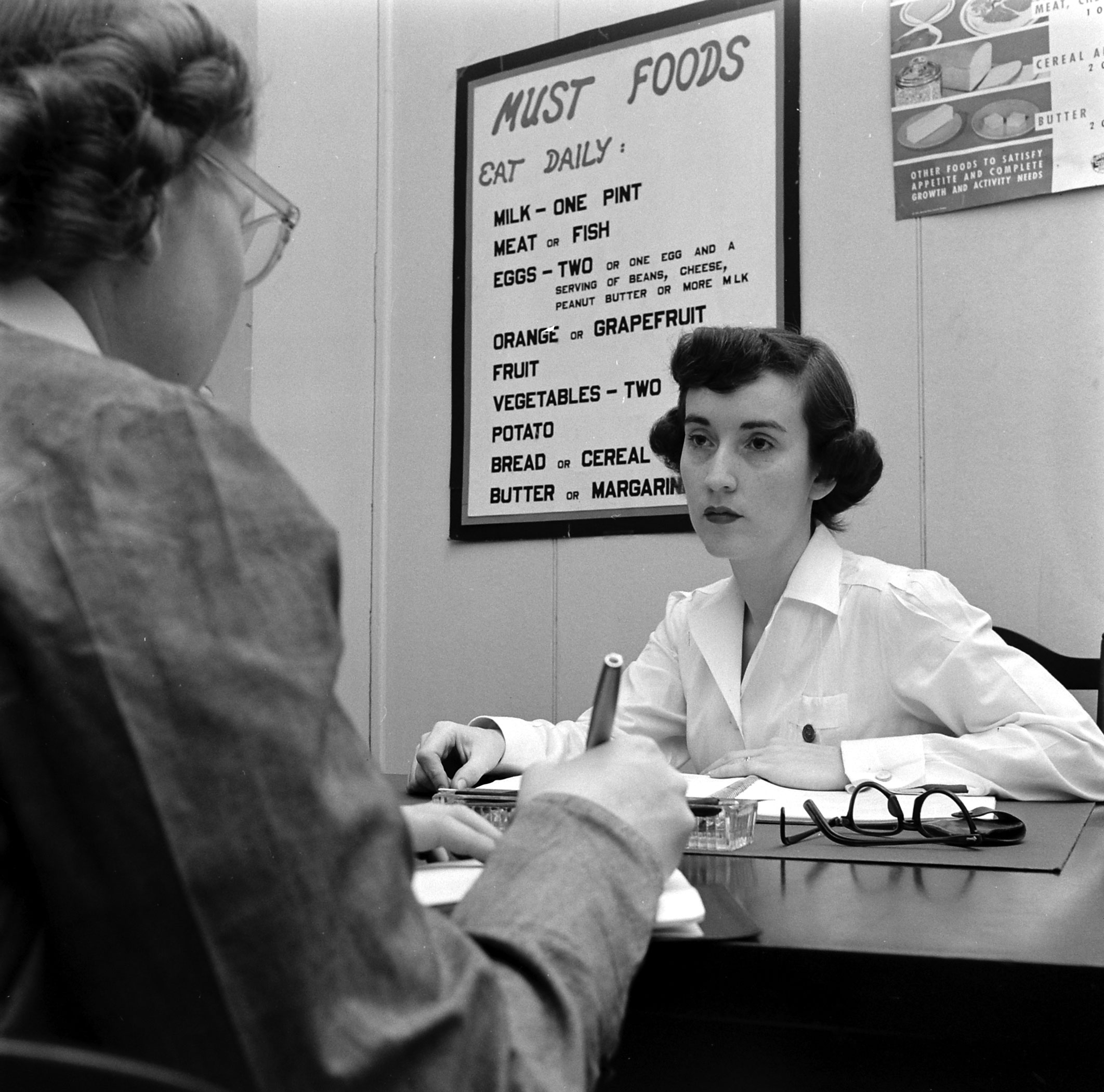 Dorothy Bradley (left), photographed for LIFE magazine article on obesity, meets with a nutritionist, 1949.