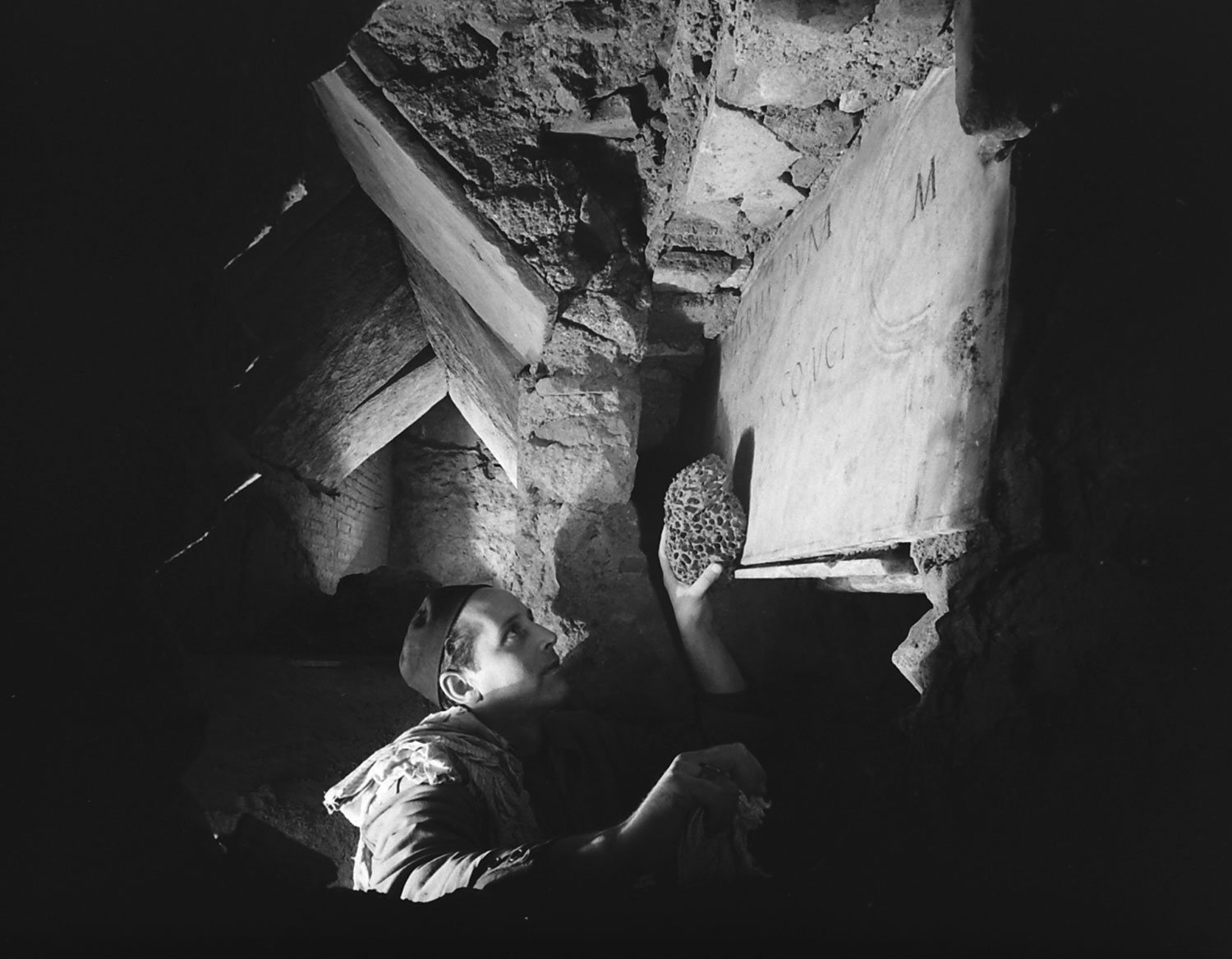 A workman cleans an inscription during the excavation beneath St. Peter's in Rome, 1950.