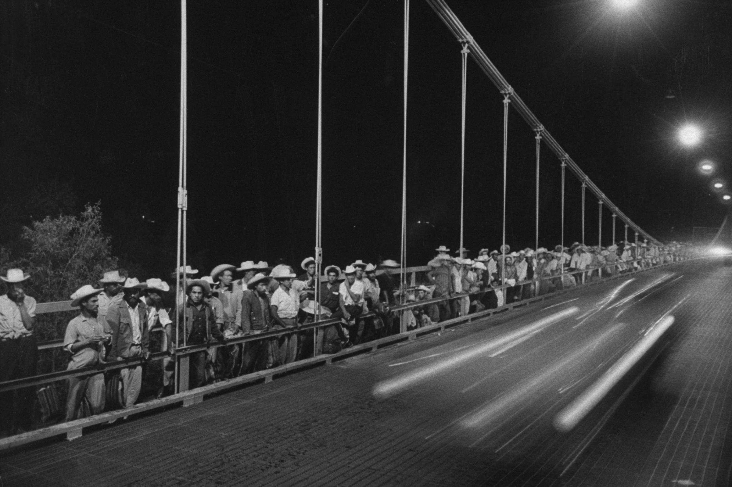 Mexican migrant farm laborers crowd International Bridge in Texas upon entering the U.S., 1959.