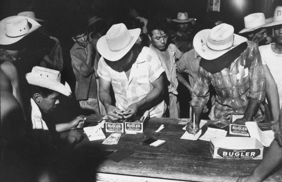 Pay night at bracero camp near Pharr, Texas. Average pay for picking cotton: $26 a week.