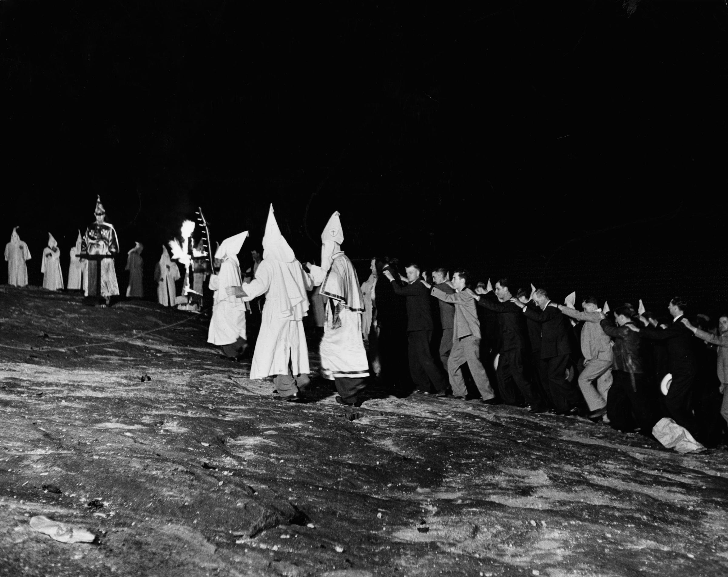 New Klan members march in lock step up to the Klan's big altar on Stone Mountain in Georgia, 1946. The Klan exultingly announced they had initiated 600 new members in one night; observers best guesses were from 150 to 200.