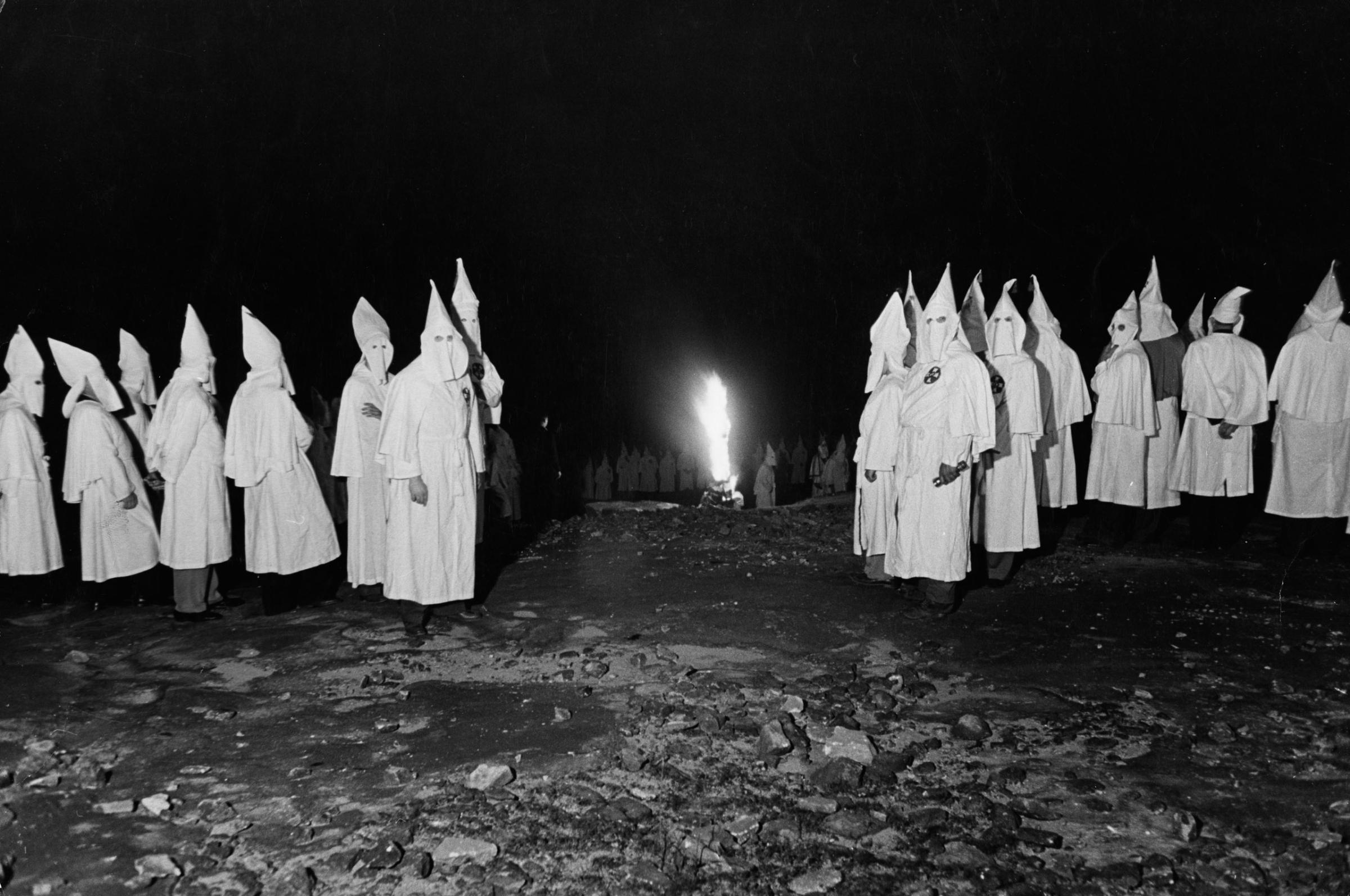 White-sheeted Ku Klux Klan members stand by a burning cross, May 1946. This Stone Mountain, Ga., ceremony was put off many times, Klansmen allegedly said, because of wartime sheet shortages during WWII.