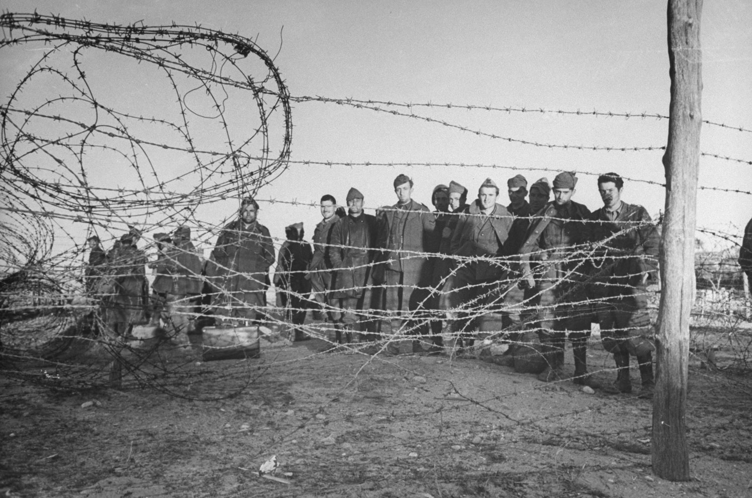 Barbed wire enclosure holds Axis prisoners taken during the Allied assault on German positions near Sened, Tunisia, 1943.