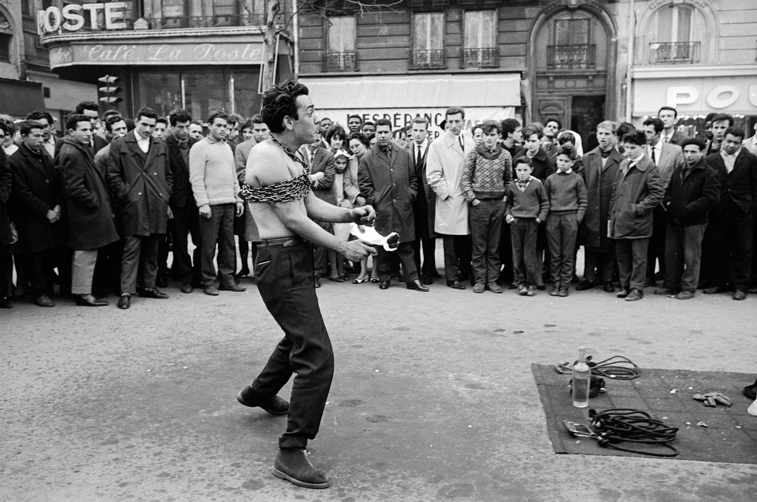 Street performer drawing a crowd, Paris, 1963.