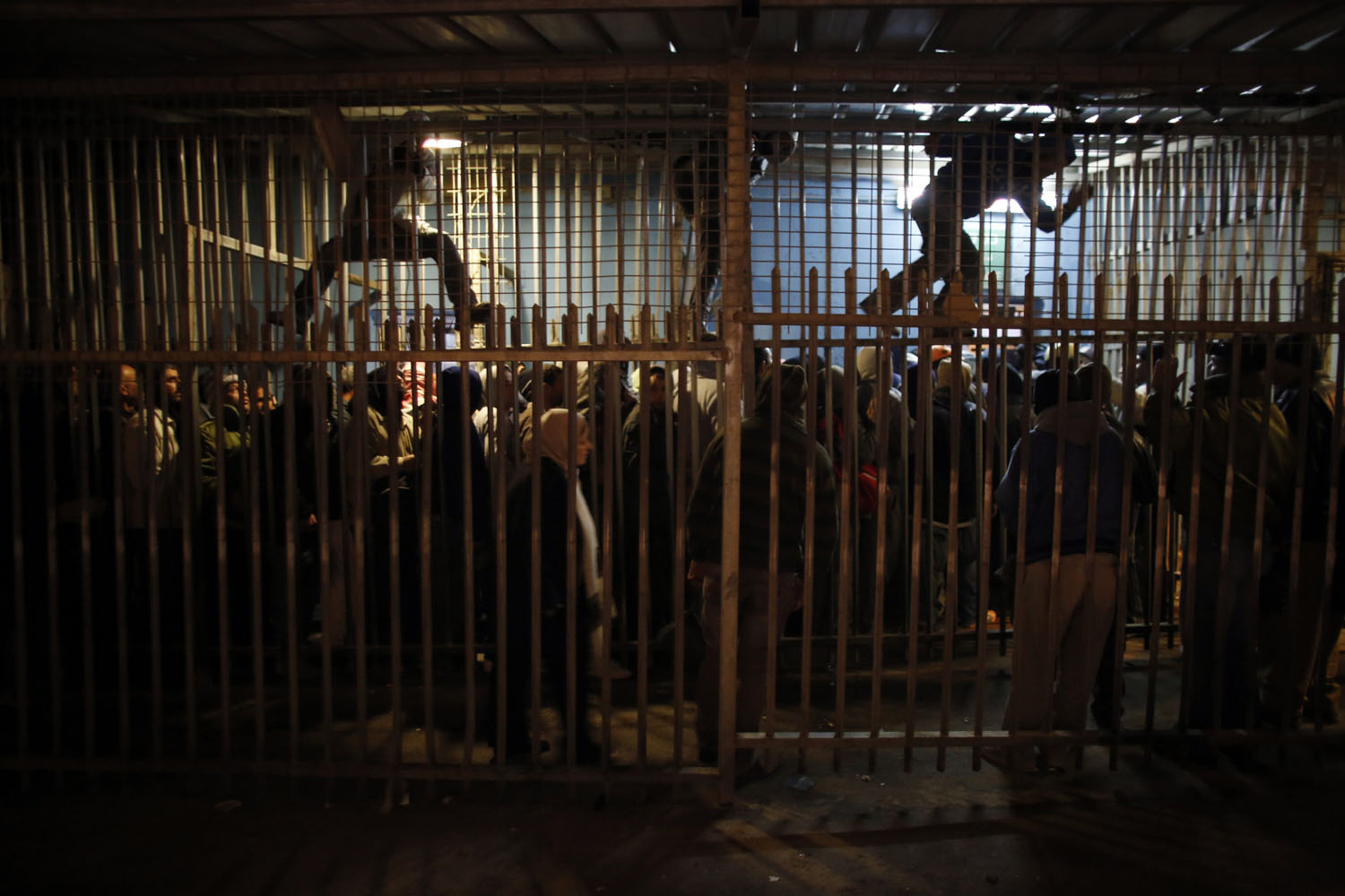 Palestinian labourers wait to cross into Jerusalem at an Israeli checkpoint in Bethlehem