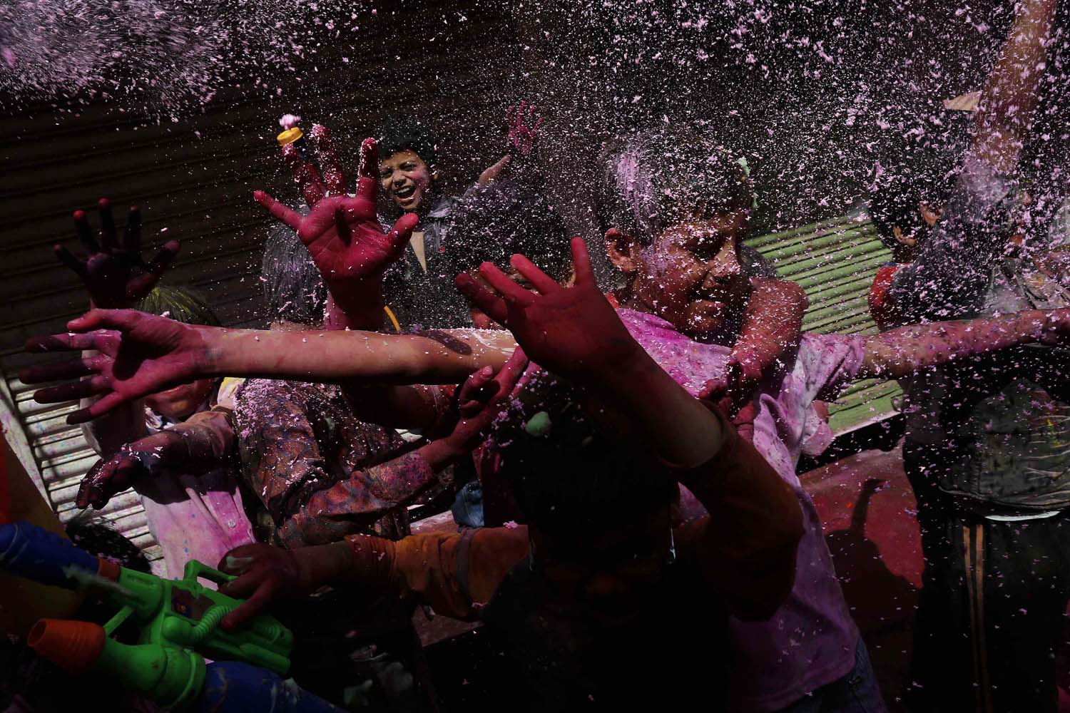 Boys spray coloured foam during Holi celebrations at a lane near the Bankey Bihari temple in Vrindavan