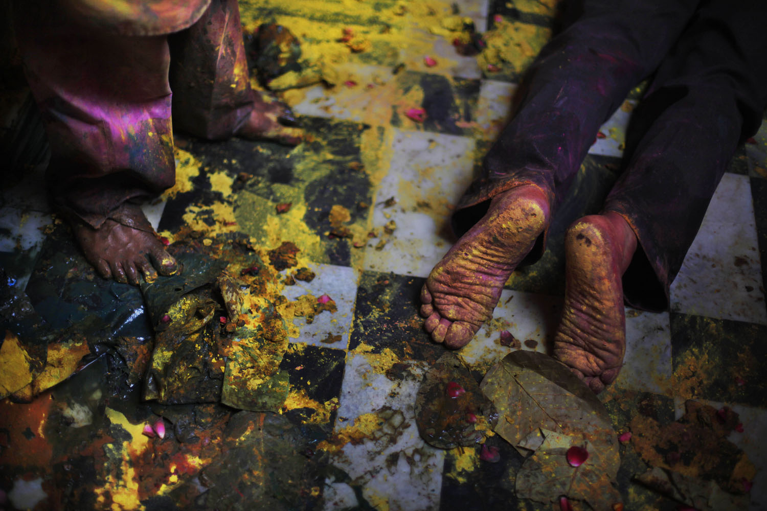 March 25, 2013. A Hindu devotee kneels down for prayers amid colors thrown inside Banke Bihari temple during Holi festival celebrations in Vrindavan, India. Holi, the festival of colors, celebrates the arrival of spring among other things.