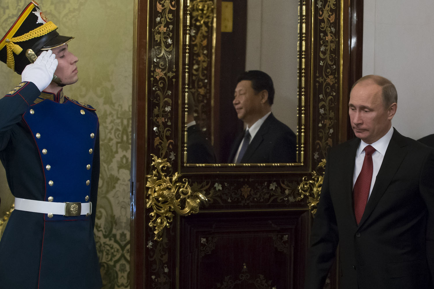 March 22, 2013. Russia's President Vladimir Putin (L) followed by  his Chinese counterpart Xi Jinping (reflected in the mirror) enters a hall before their talks in the Grand Kremlin Palace in Moscow. Xi Jinping arrived today in Moscow on his first foreign trip, to cement ties between the two countries by inking a raft of energy and investment accords.