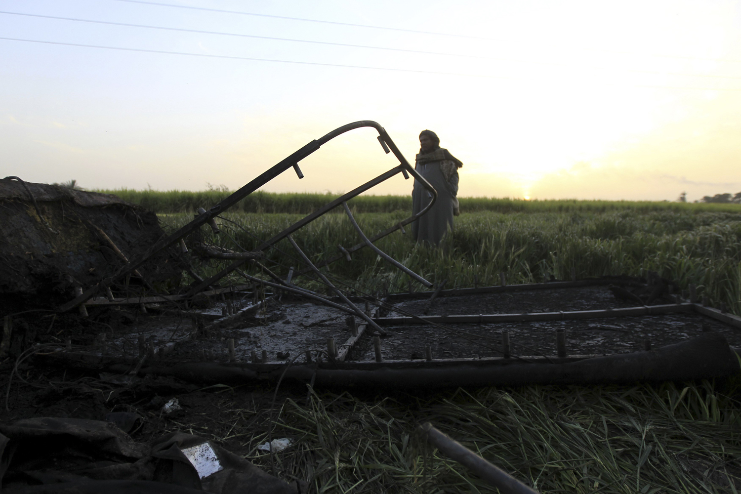 A night watchman stands guard near the wreckage of a hot air balloon that crashed in Luxor