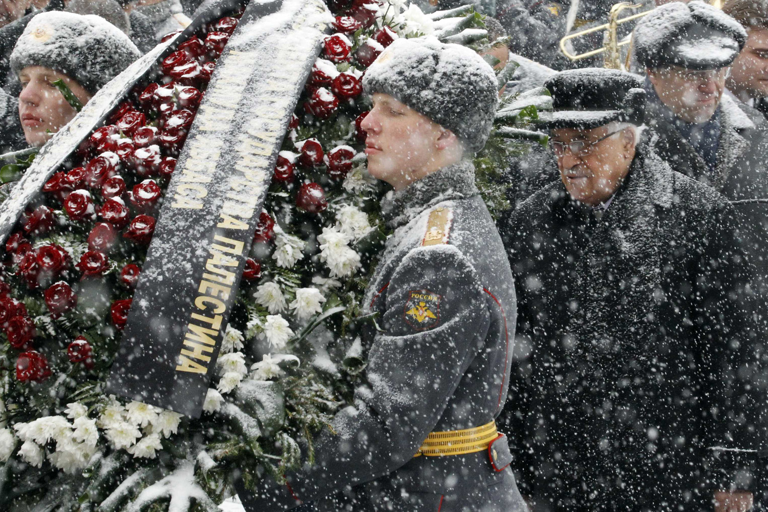 Palestinian President Mahmoud Abbas takes part in a wreath laying ceremony under a heavy snowfall at the Tomb of the Unknown Soldier near the walls of Moscow's Kremlin